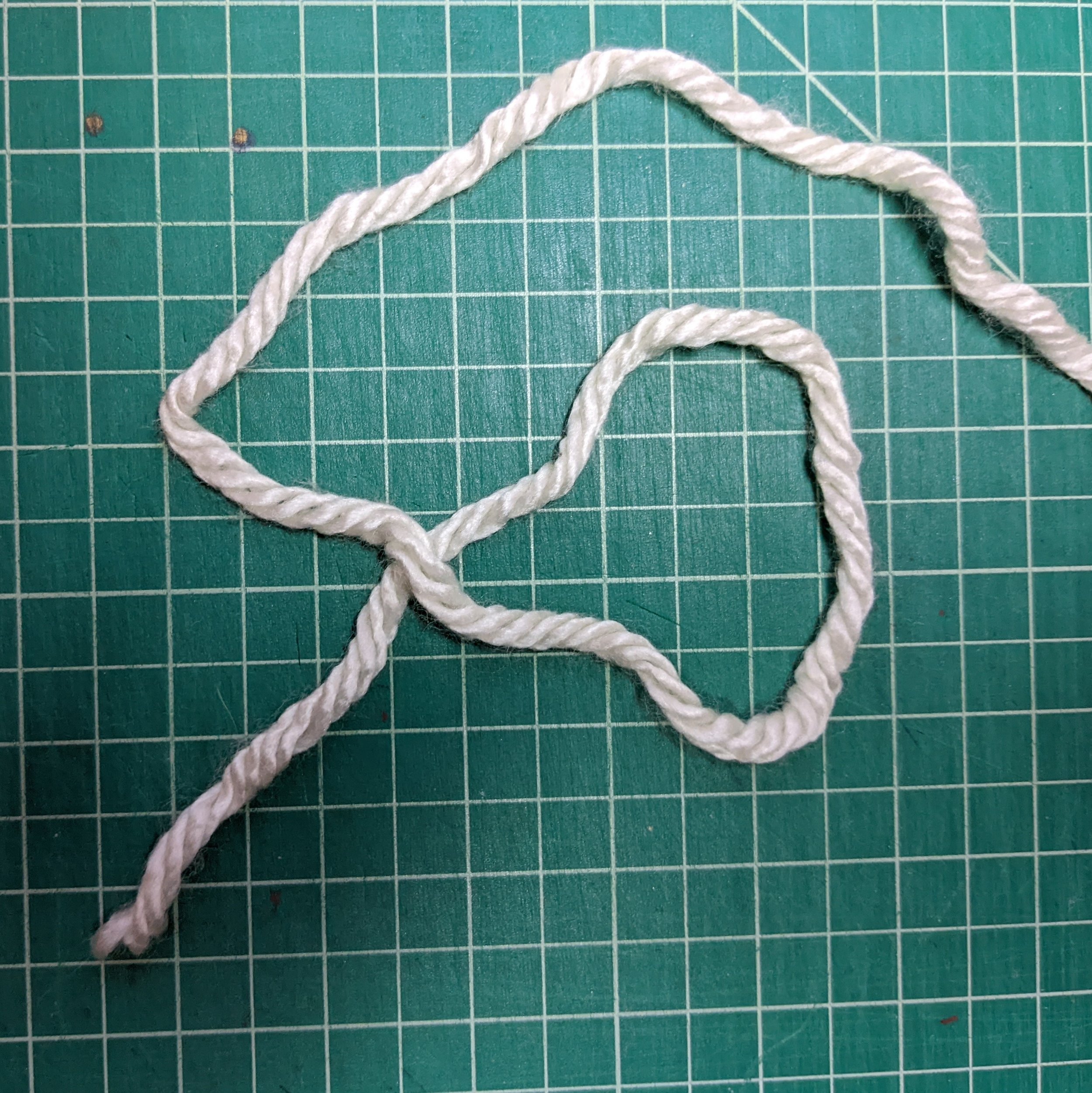 Step 2: Move the right yarn over the left yarn to make a loop