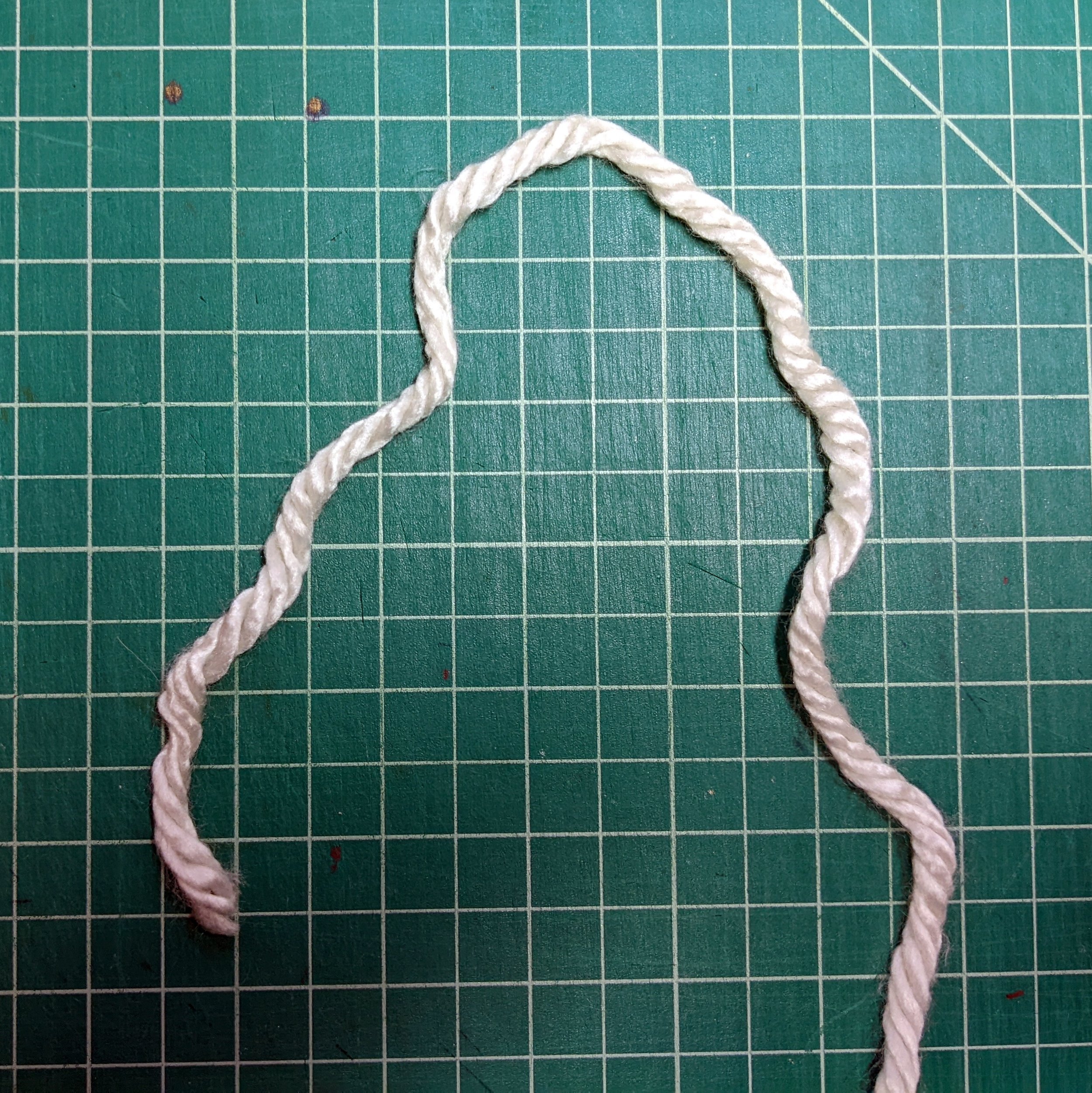 Step 1: Start with the short end of the yarn on the left and the end that connects to your ball of yarn on the right.