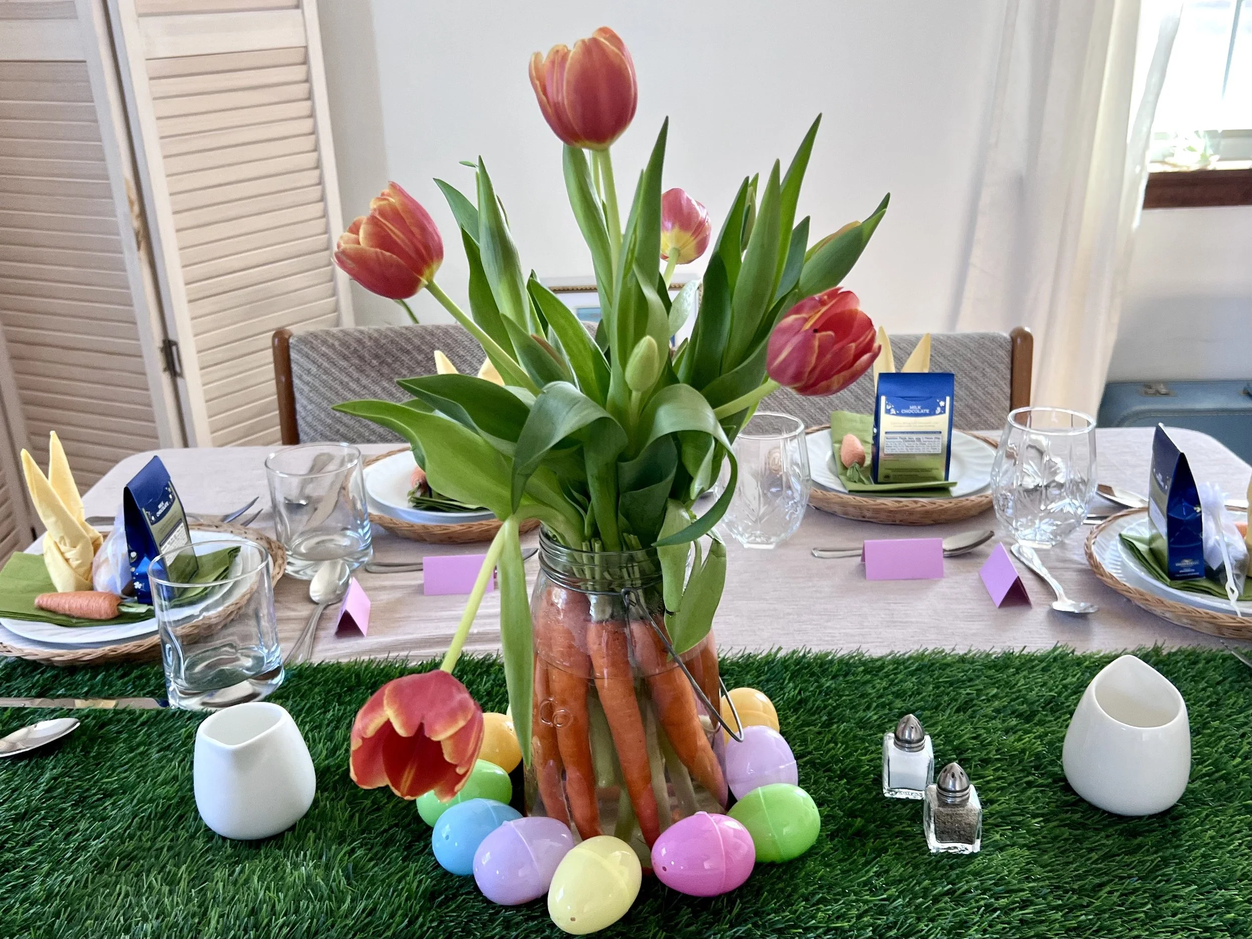 Mason jar lined with whole carrots and tulips in the center with water