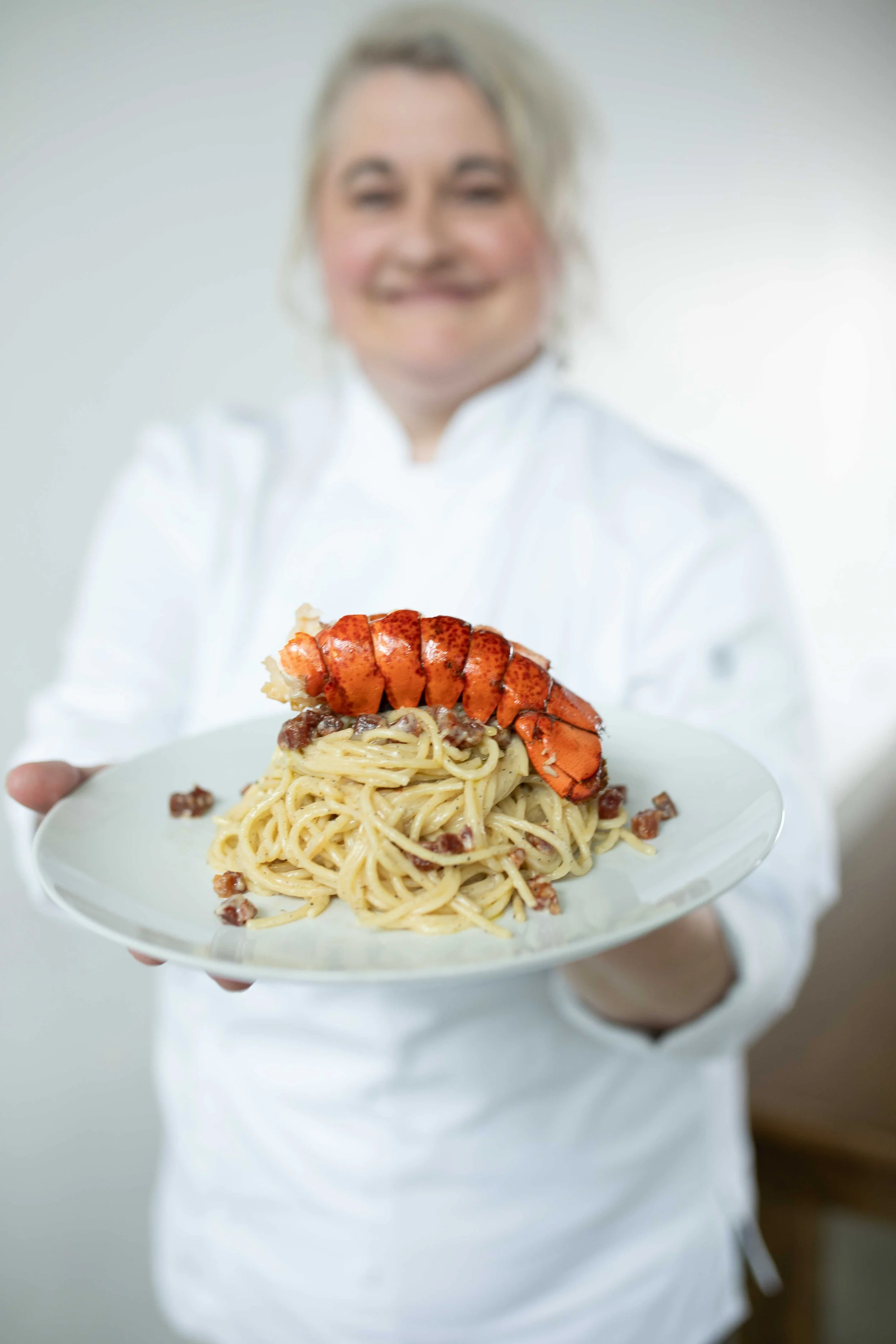 Butter poached lobster tail on a bed of cacio e pepe spaghetti with pancetta