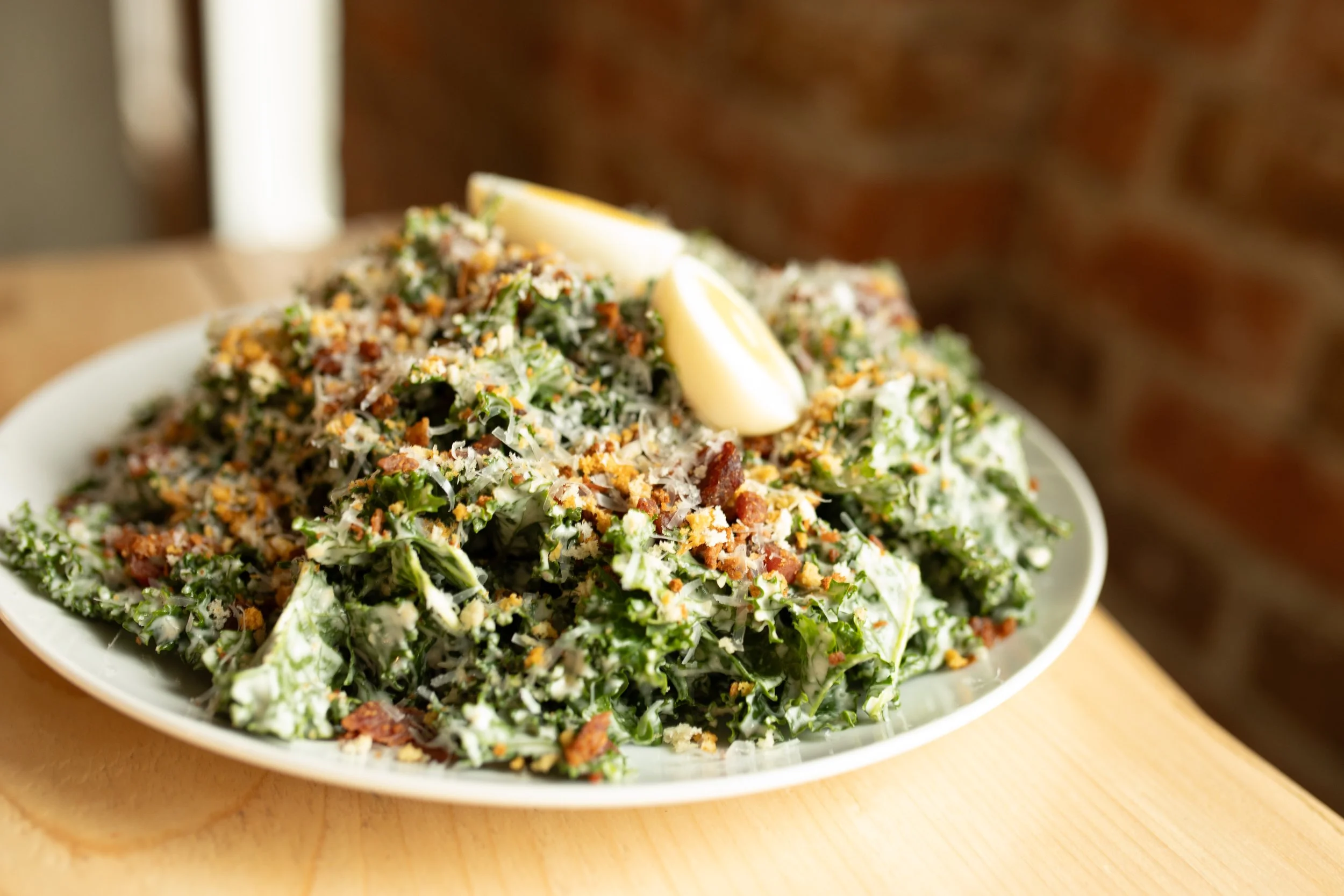 Kale Caesar with parmesan Reggiano, rosemary panko, smoked bacon bits, rainbow kale, hard boiled egg & creamy confit garlic dressing