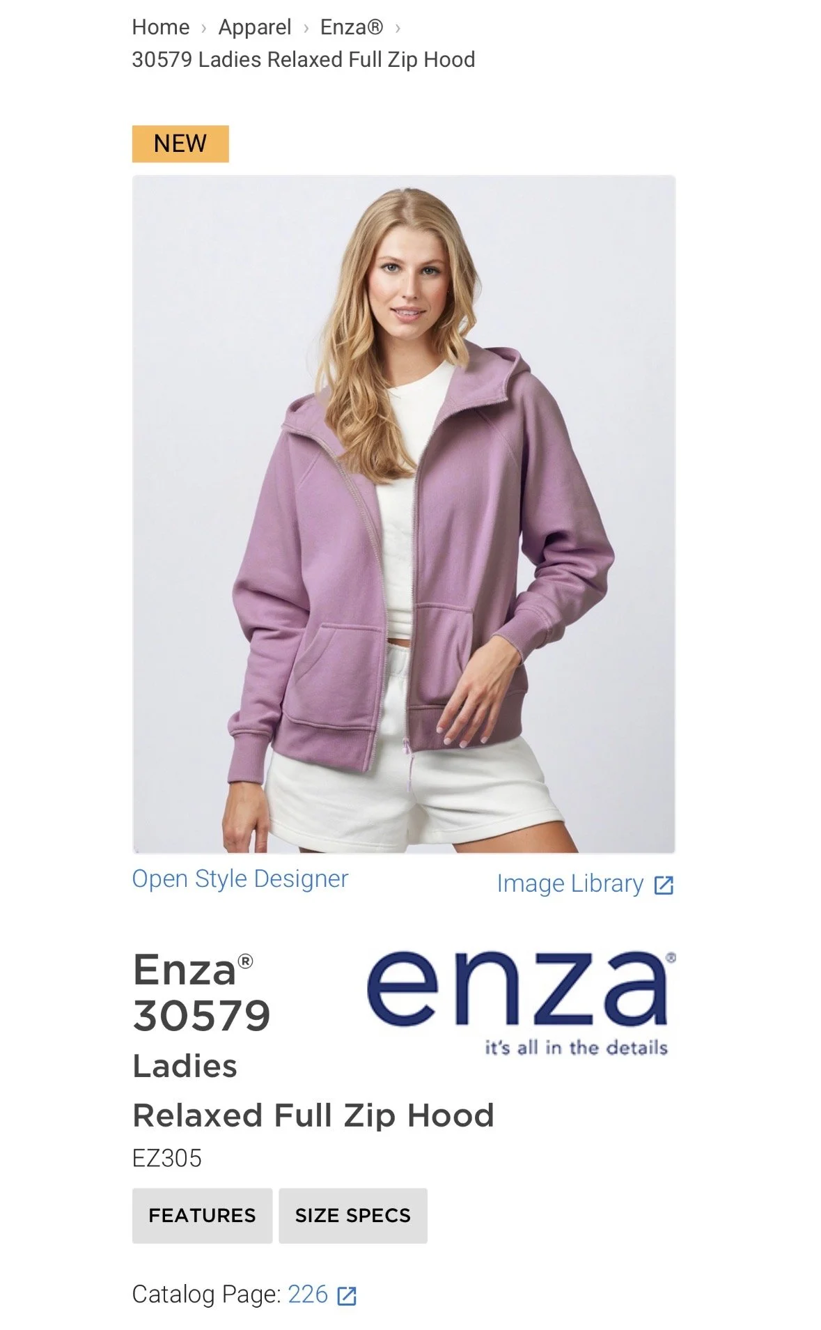 A woman wearing a lavender zip-up hoodie and white shorts, standing against a light background. hairstylist-metro-detroit-bridal-hair-updo-effortless-engaged