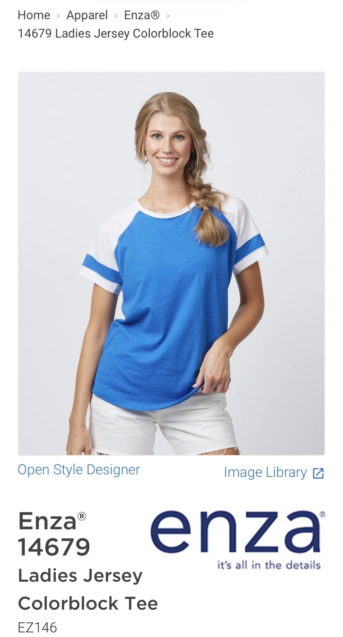 A young woman with blonde hair styled in loose waves, wearing a blue and white raglan T-shirt and white shorts. She is smiling and posing with her right hand on her hip against a plain light gray background. hairstylist-metro-detroit-bridal-hair-updo