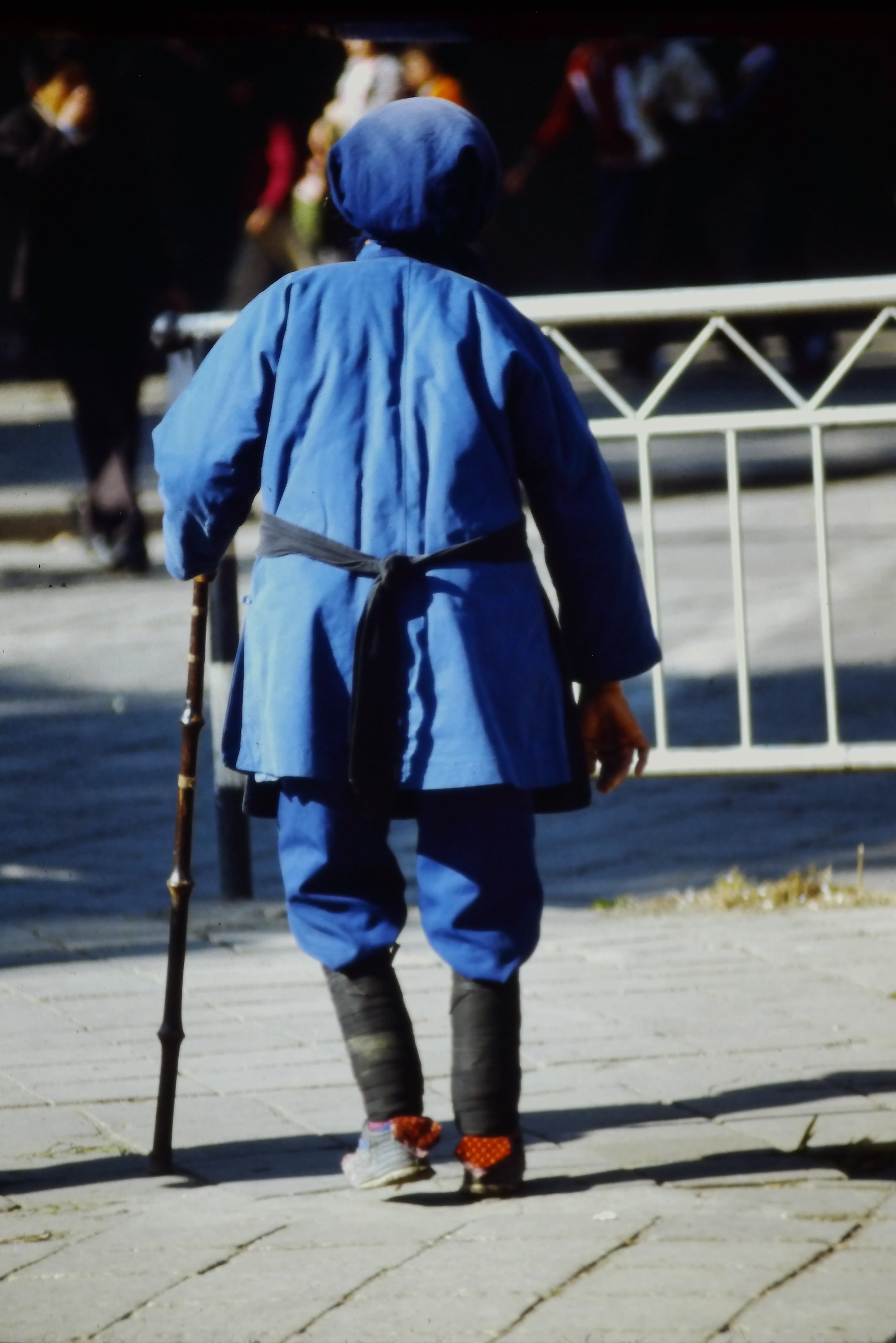 BOUND-FOOTED WOMAN WALKING