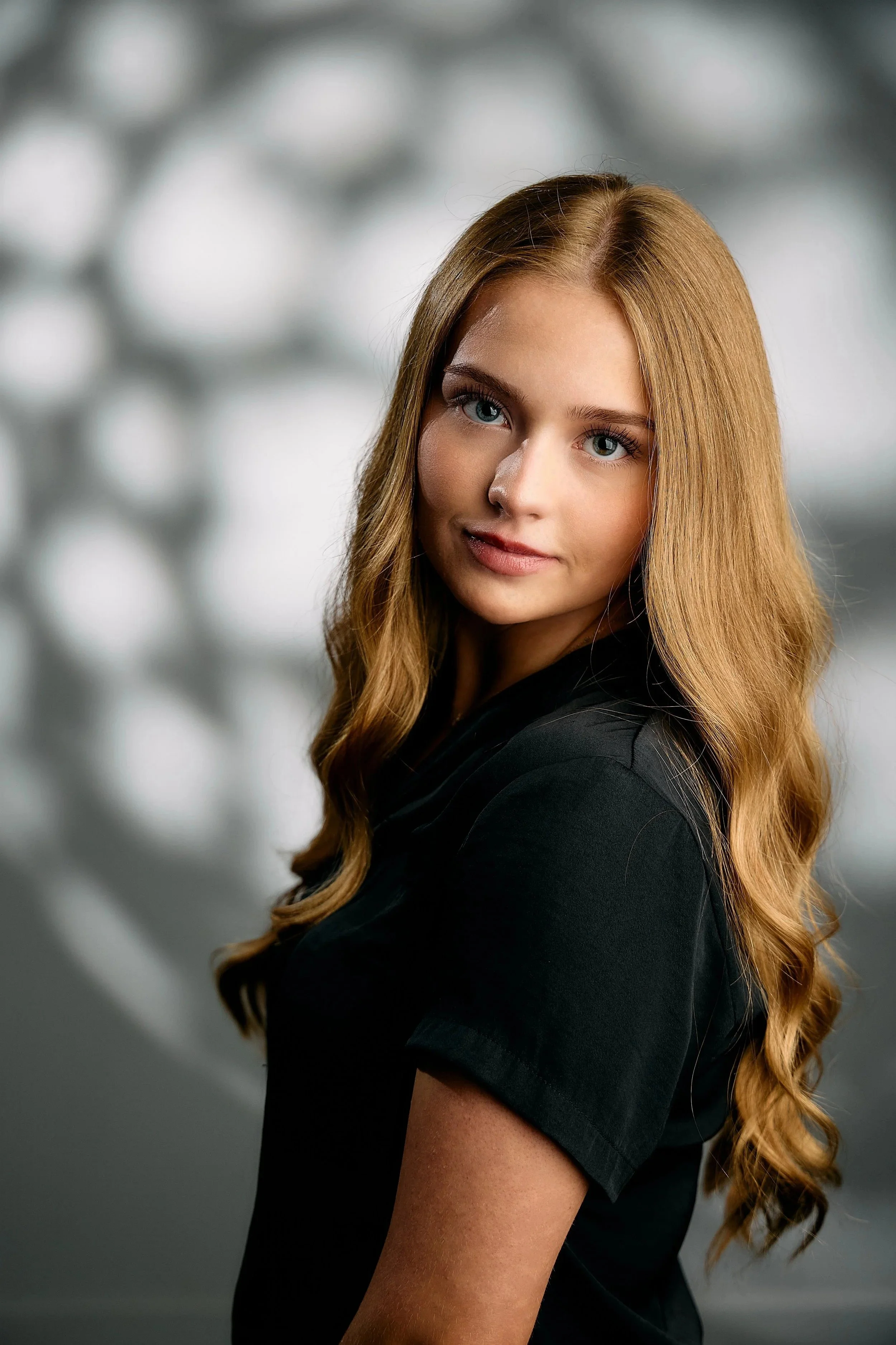 Senior portrait for a gallery wall: girl with long wavy blonde hair in a black top