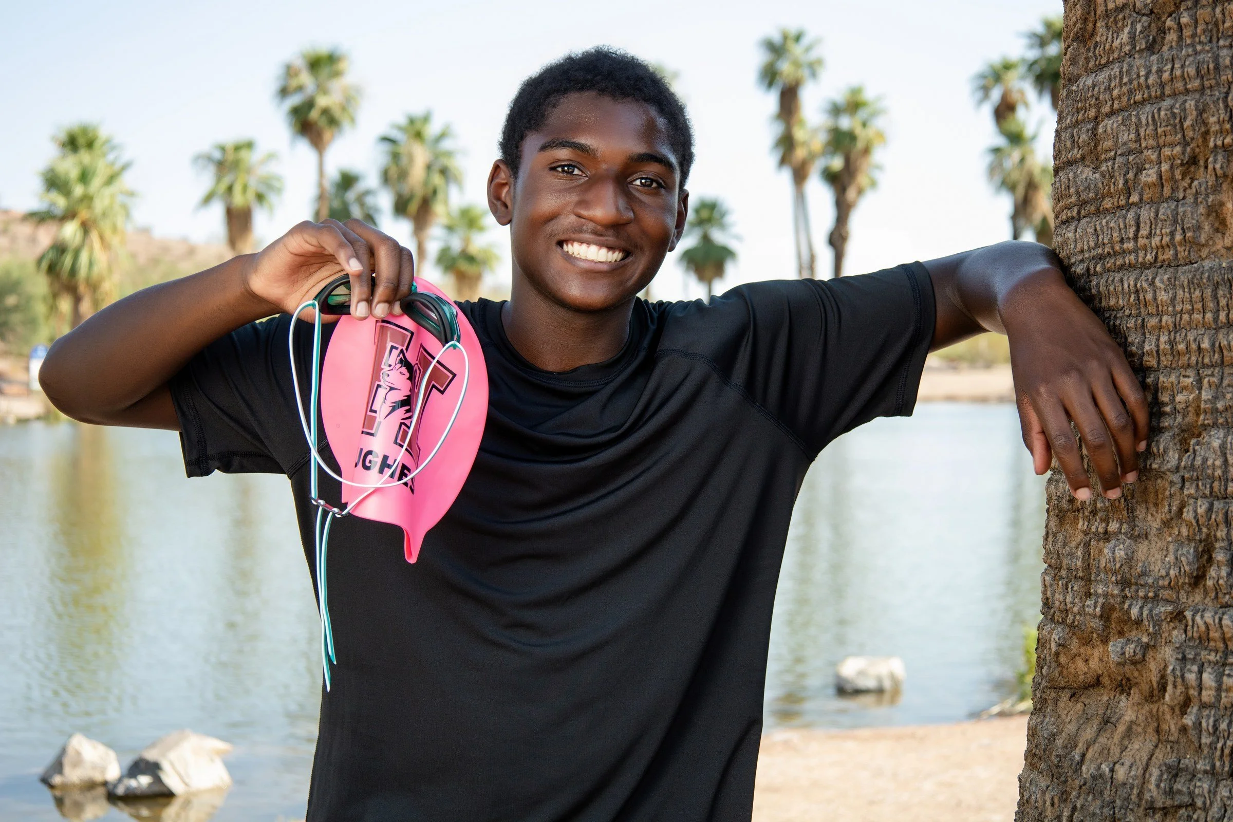 Phoenix senior pictures - Kai holding swim gear by the pond