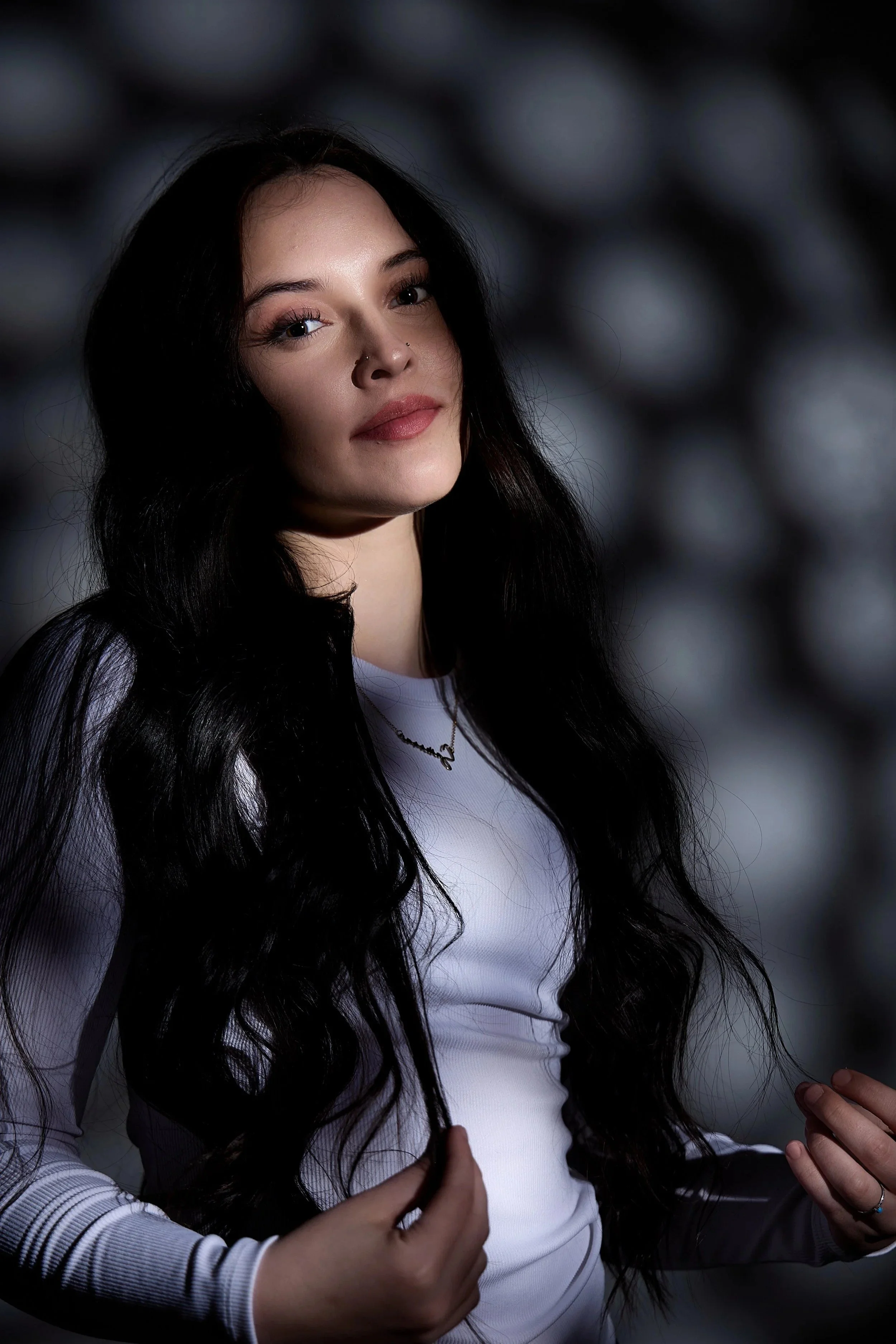 Senior portrait for wall art: girl with long black hair in a white shirt and necklace outdoors