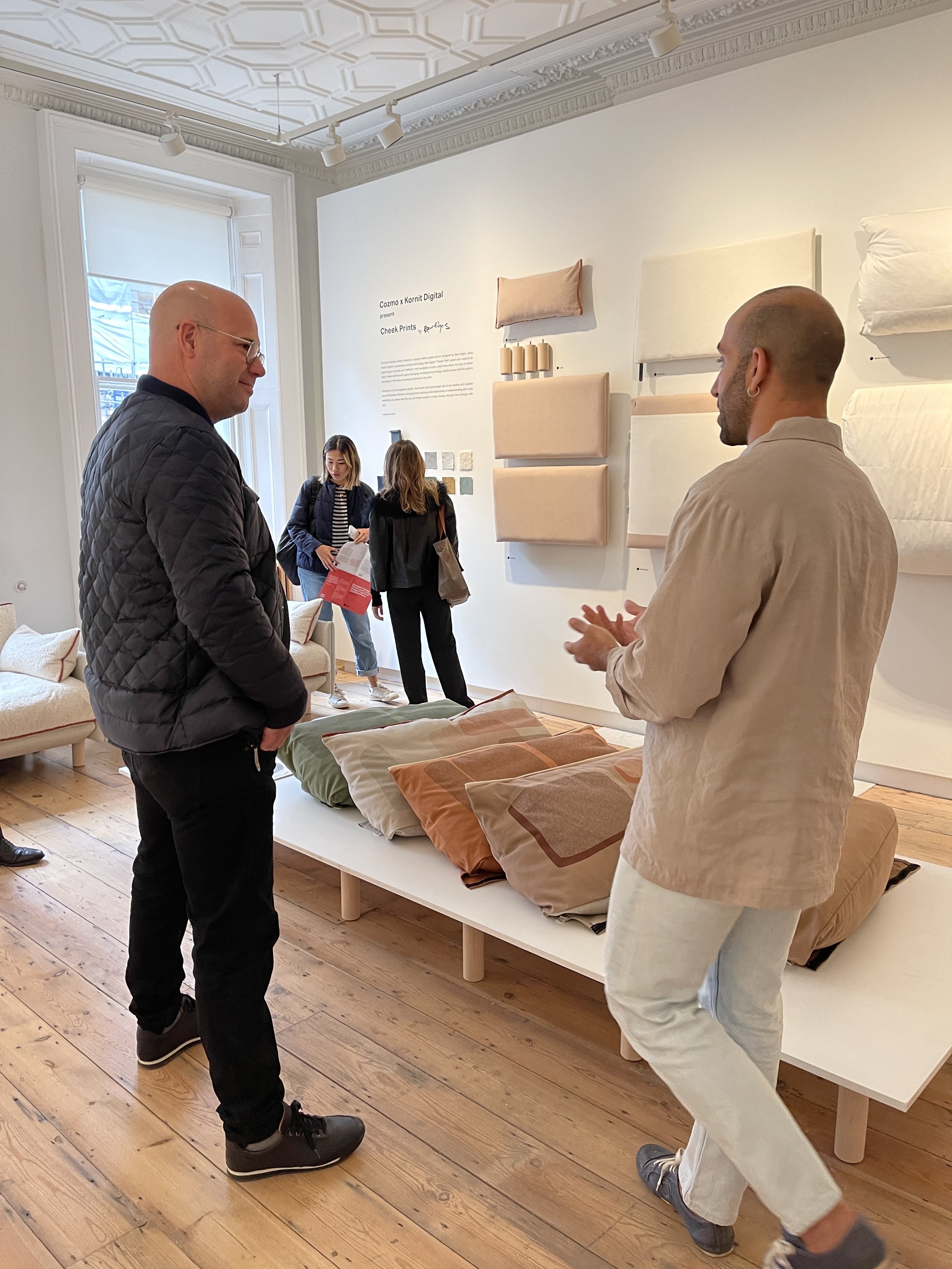 People inside a store or showroom looking at couch cushions and fabric samples