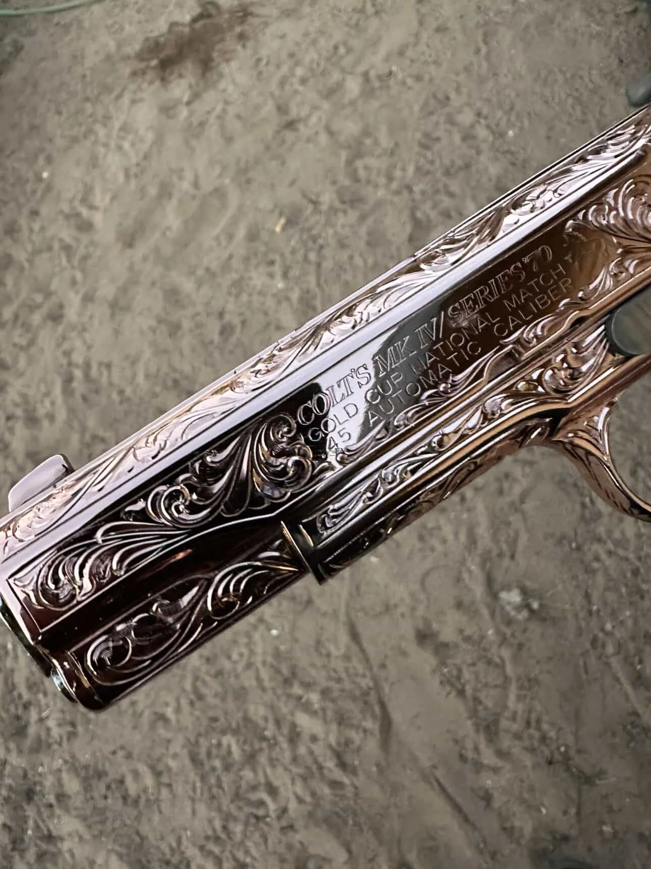 Close-up of custom engraved and rose gold plated Colt 1911..