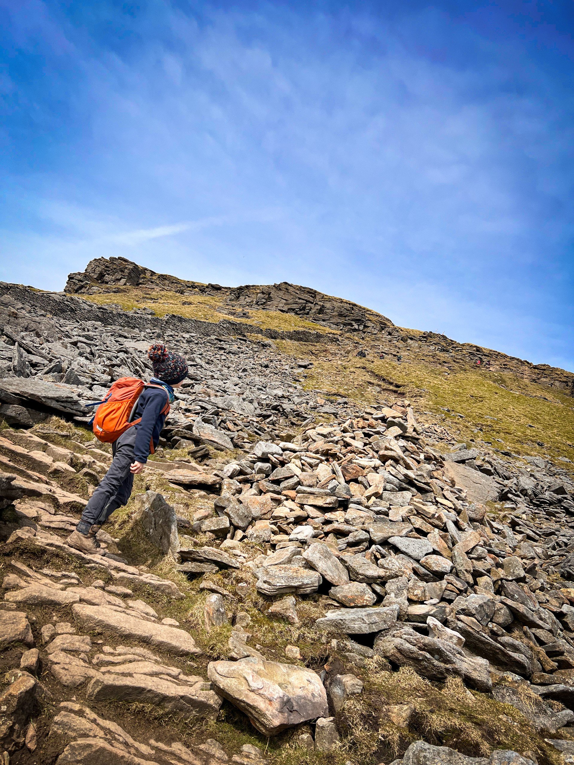 Child looking up a stony path towards a rocky outcrop