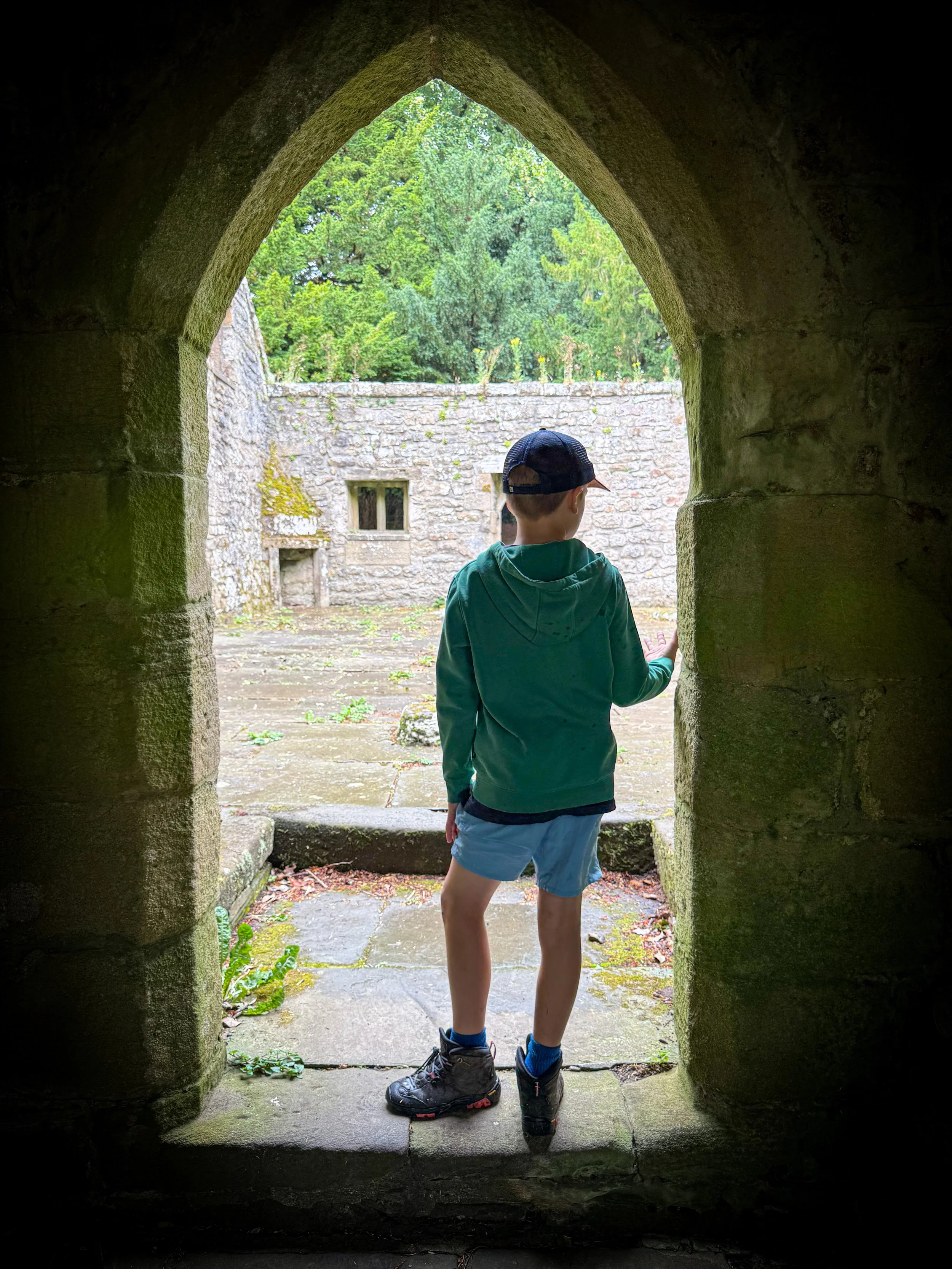 Child standing in a stone doorway of a ruined church