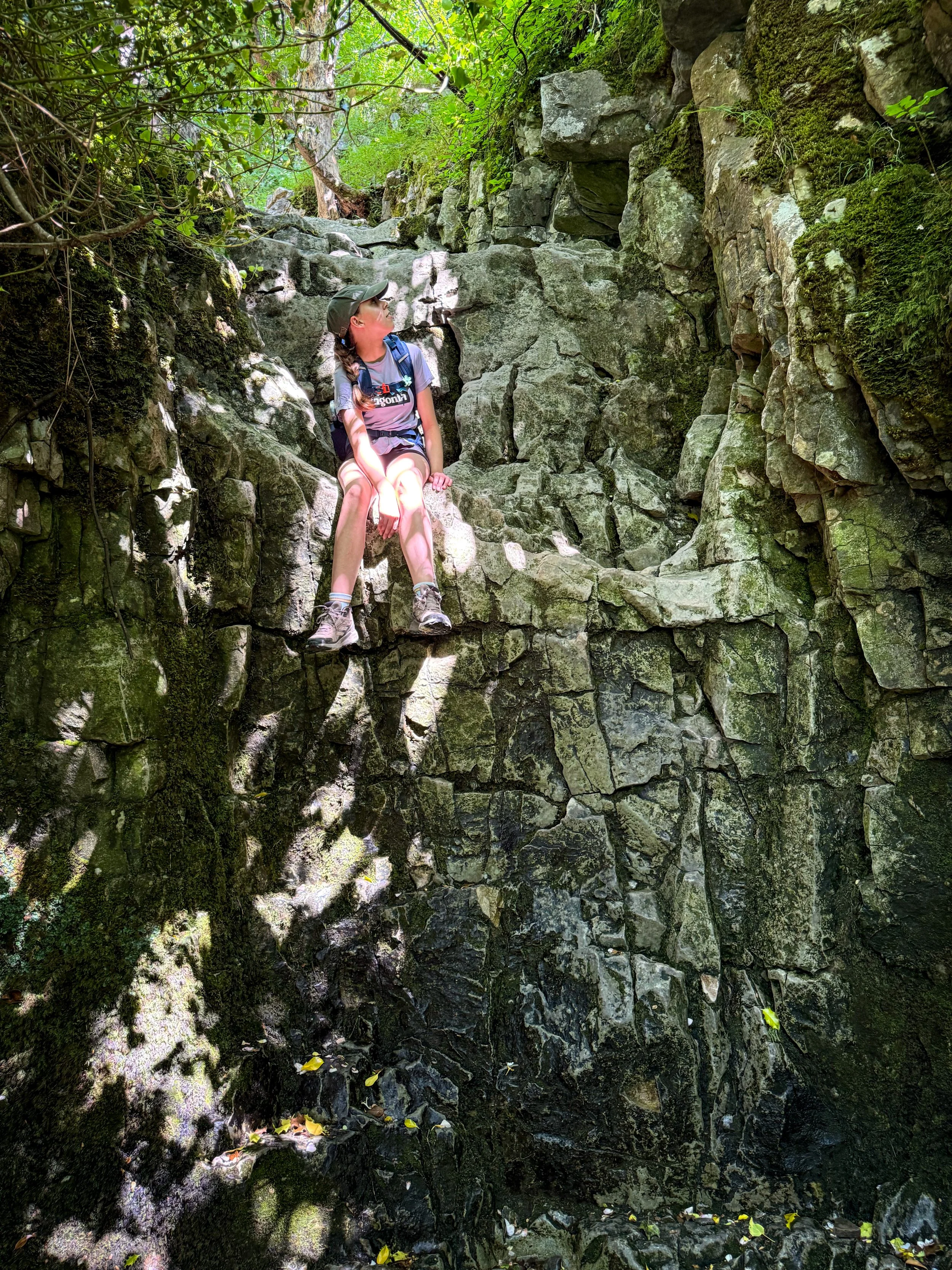 Child sitting on a rocky crag face in the sunshine