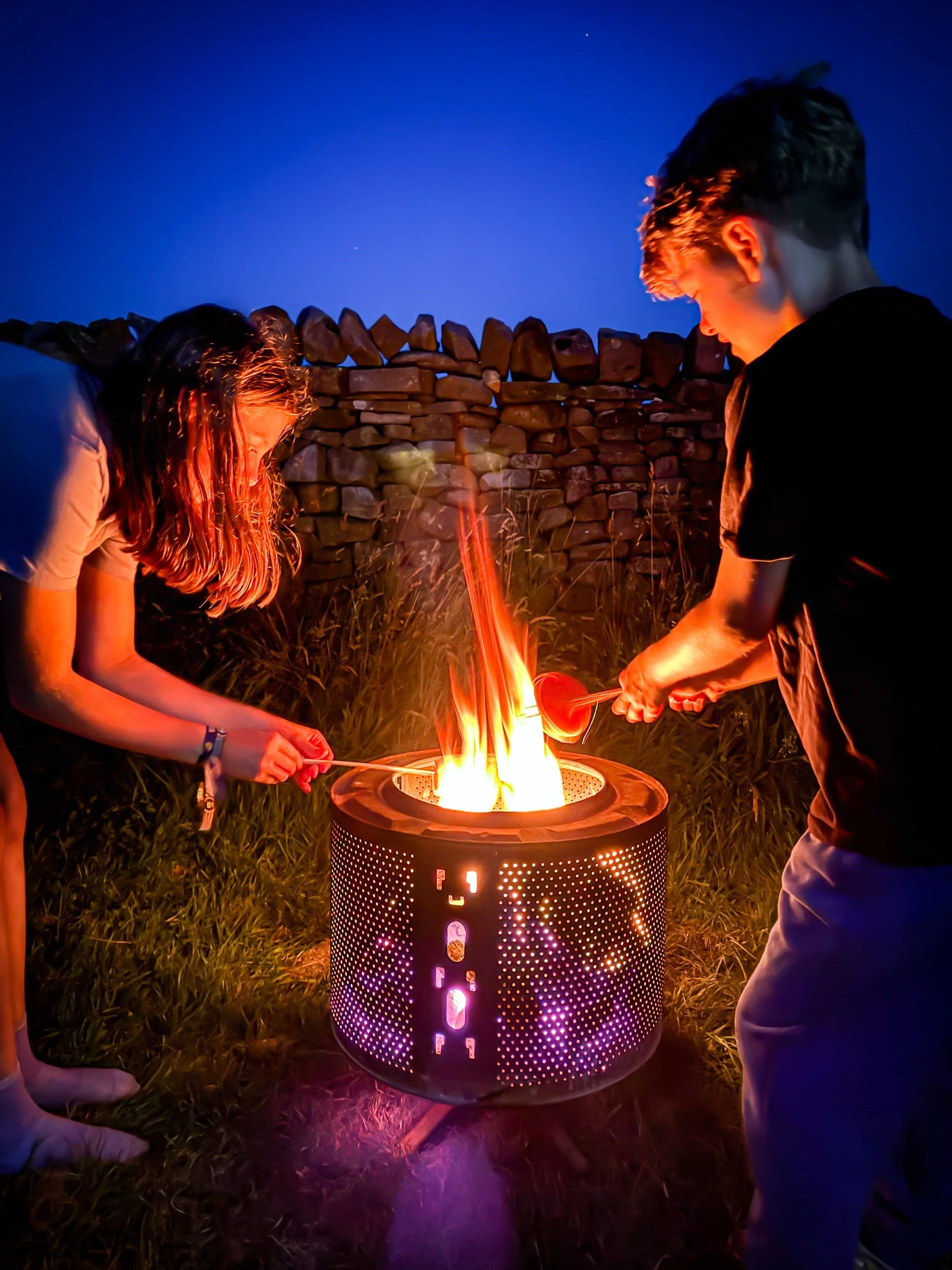 two children toasting marshmallows over the campfire
