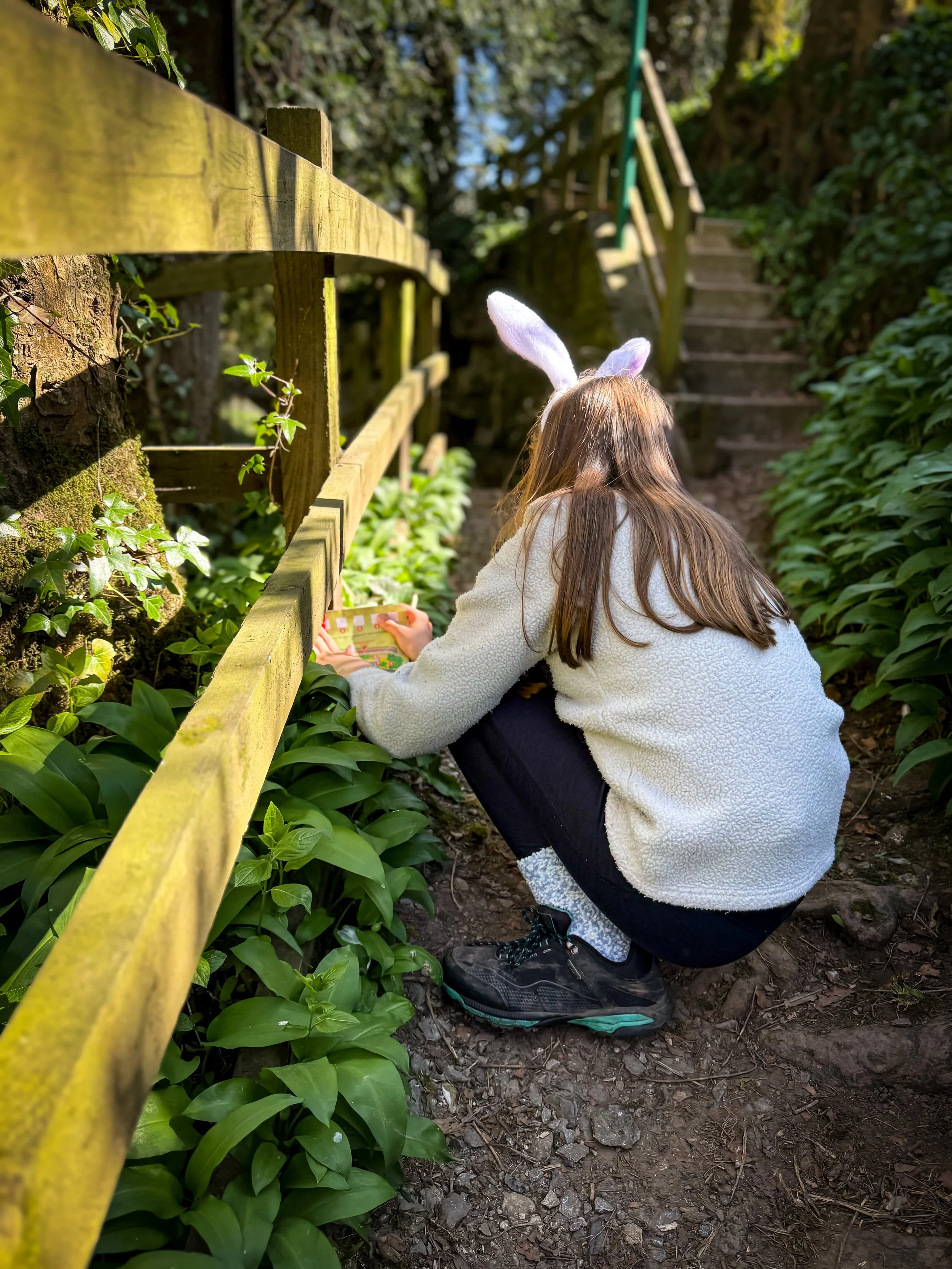 Child in rabbit ears doing a trail map