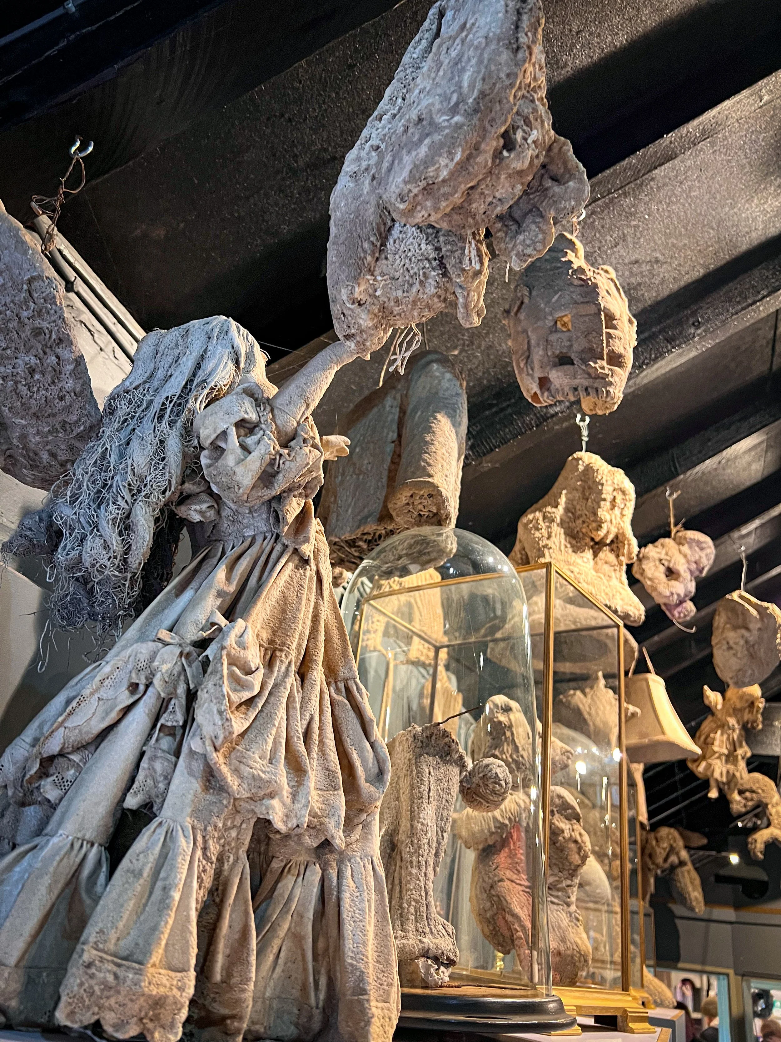 Items that have been turned to stone including a spooky doll with upstretched arms