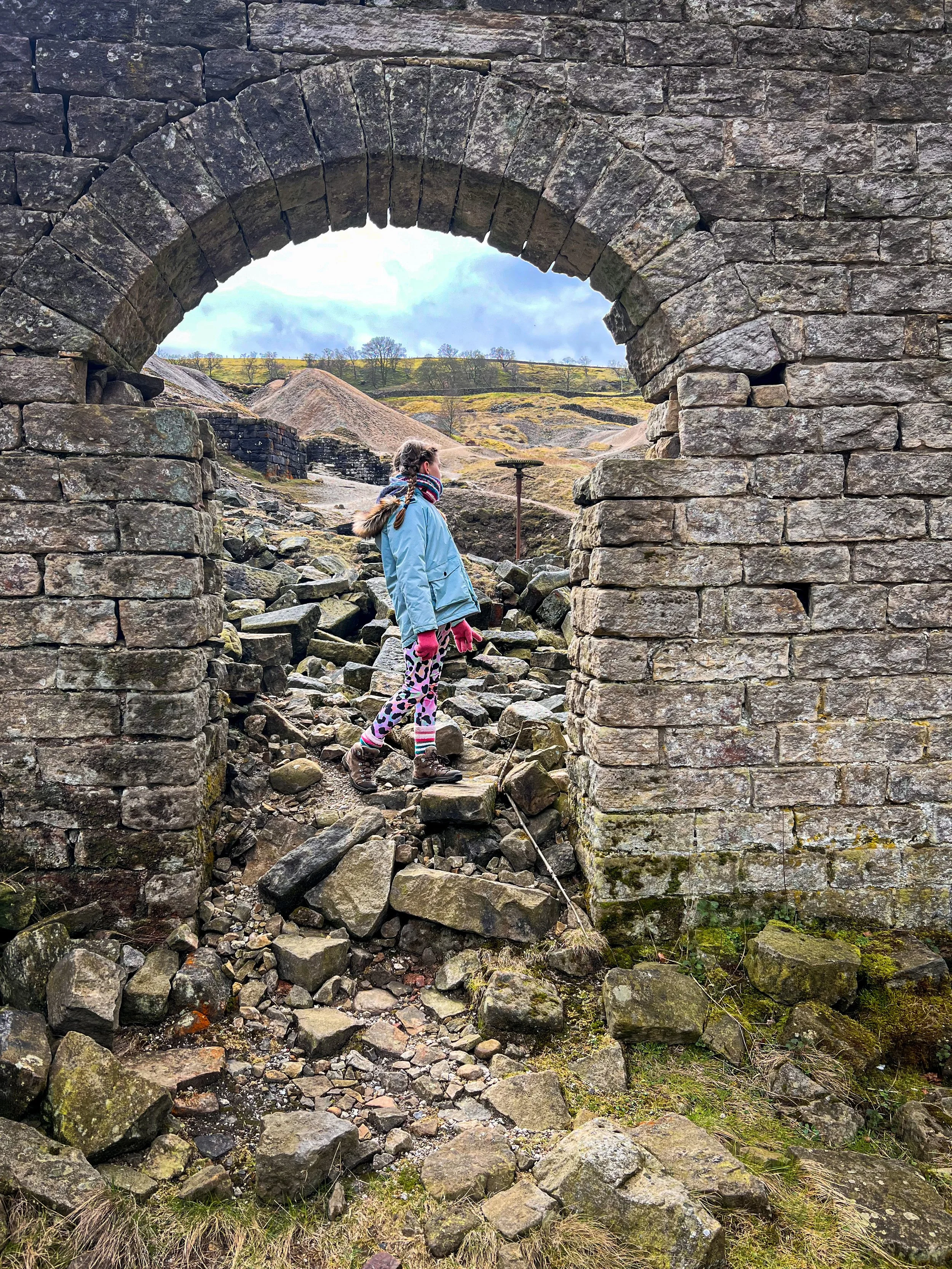 A child stood in the ruins of a mining building