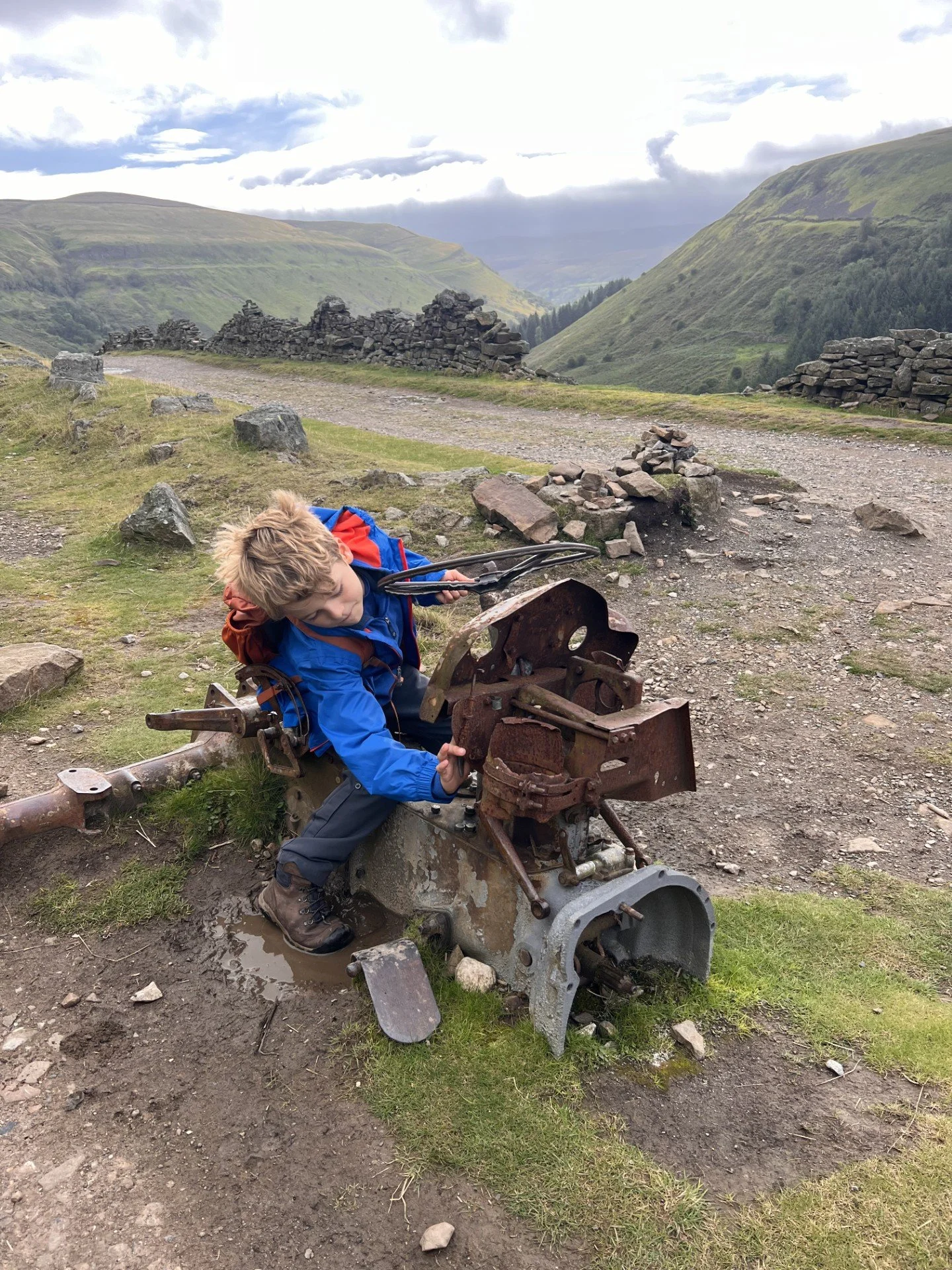Child sat on a piece of old machinery