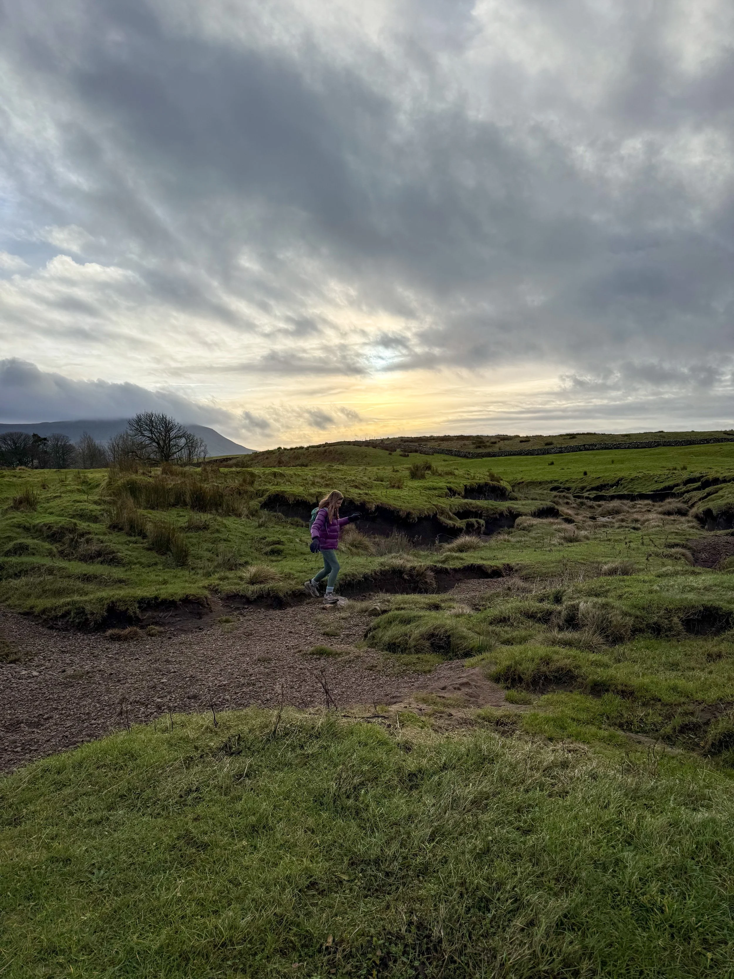 The dry beck with low winter sun and child crossing
