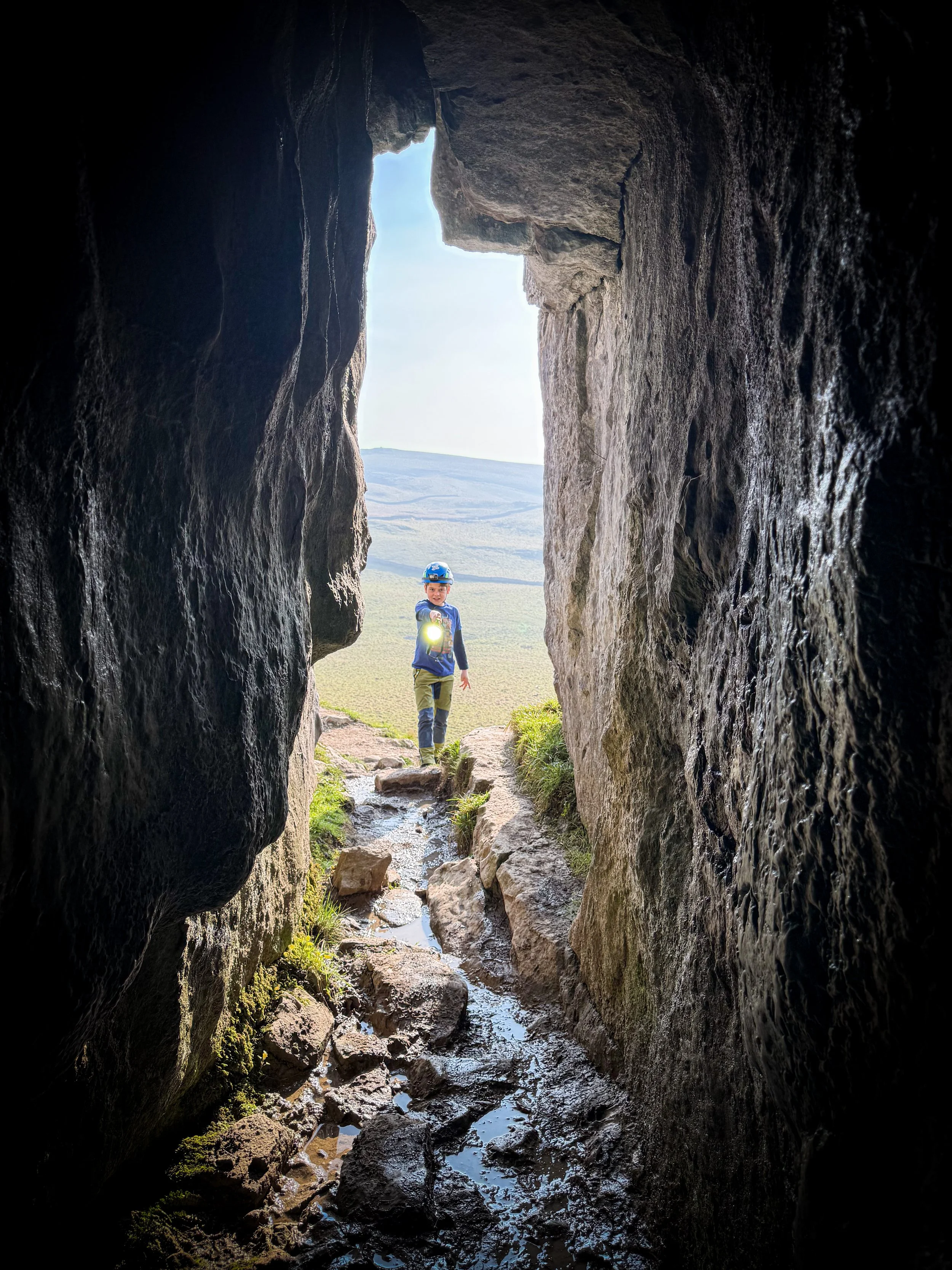 Child with torch at the mouth of a cave