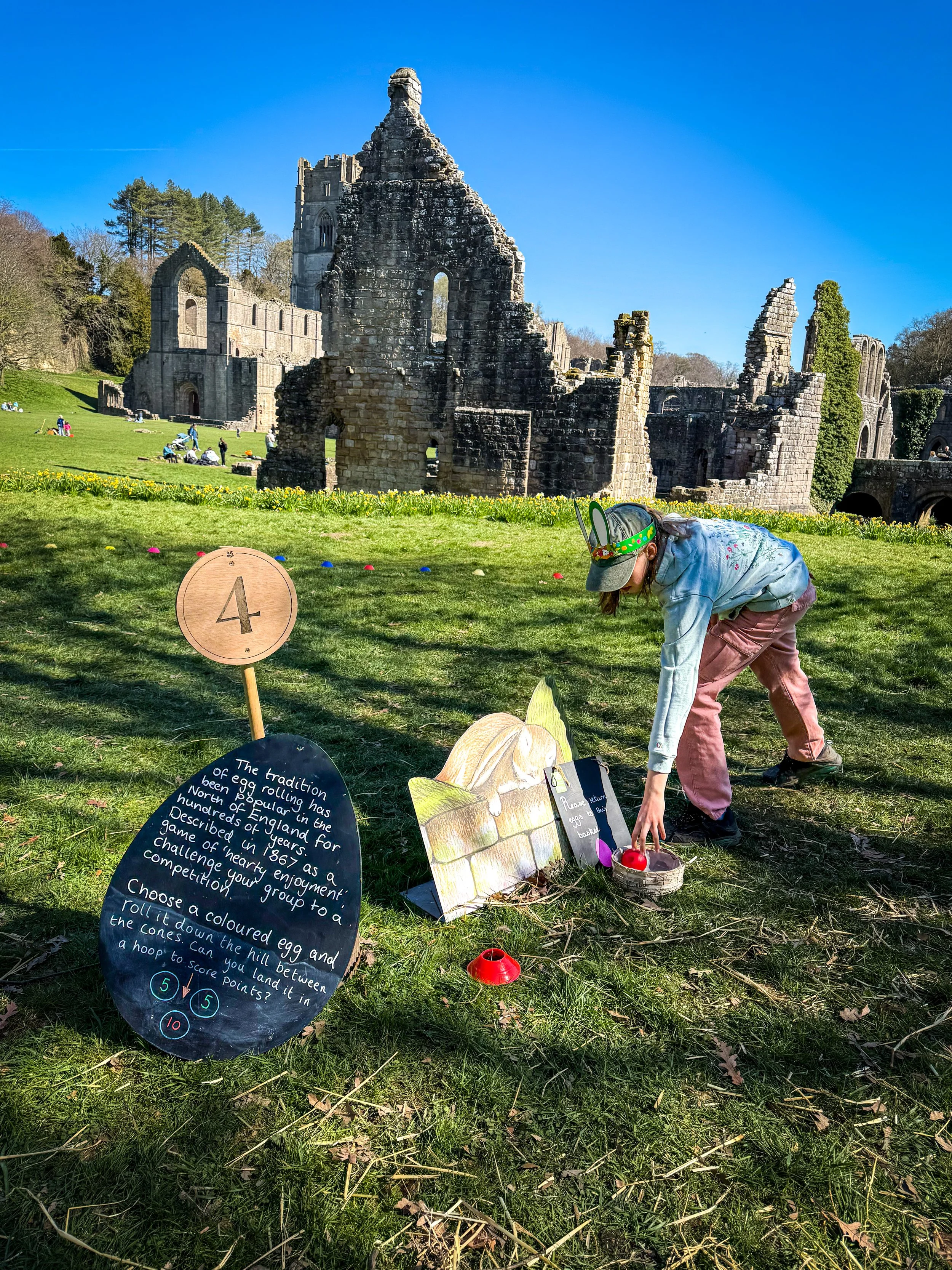 Children doing activities in front of abbey ruins in Spring