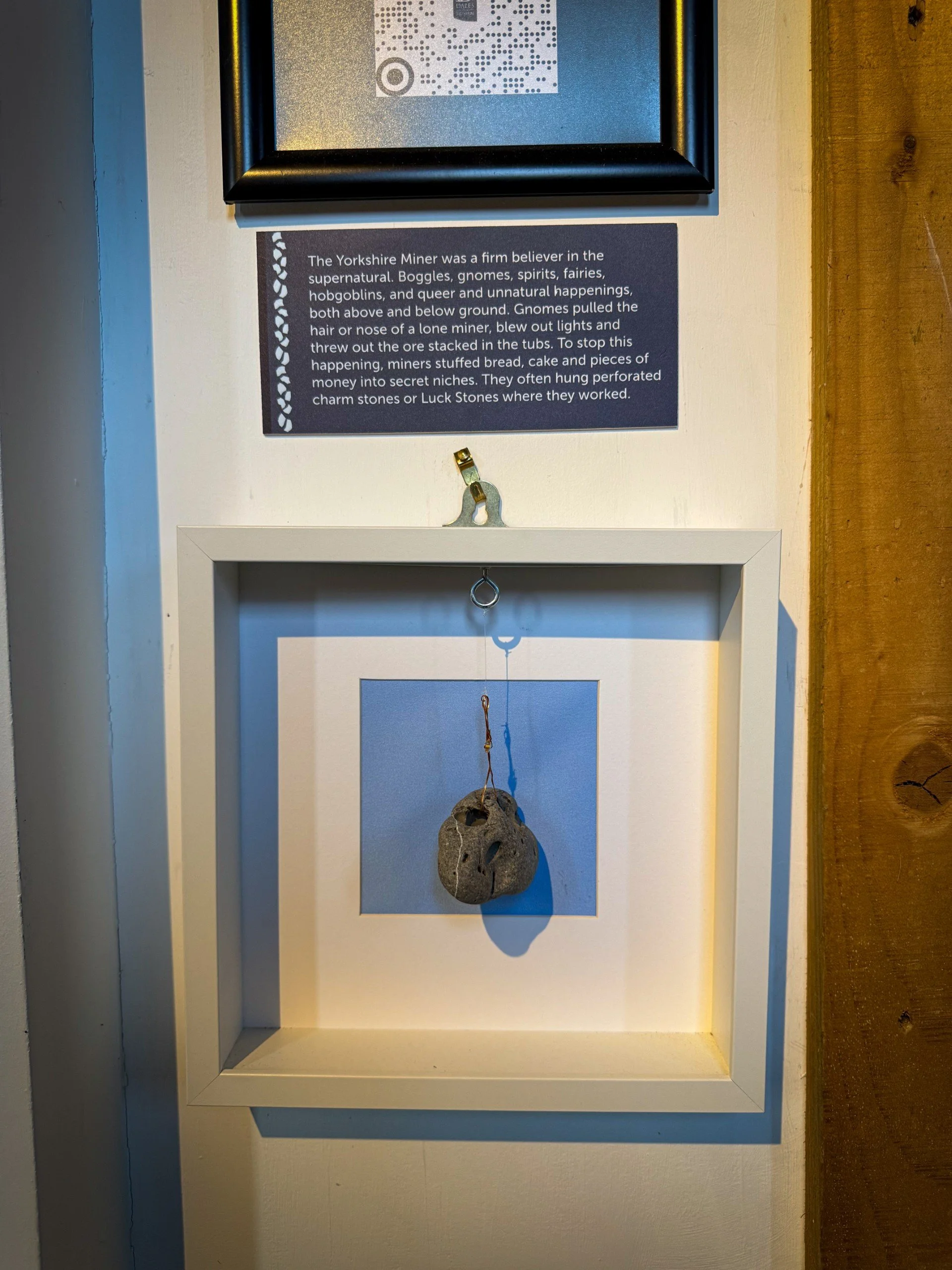 An image of a boggle stone with information plaque in a museum