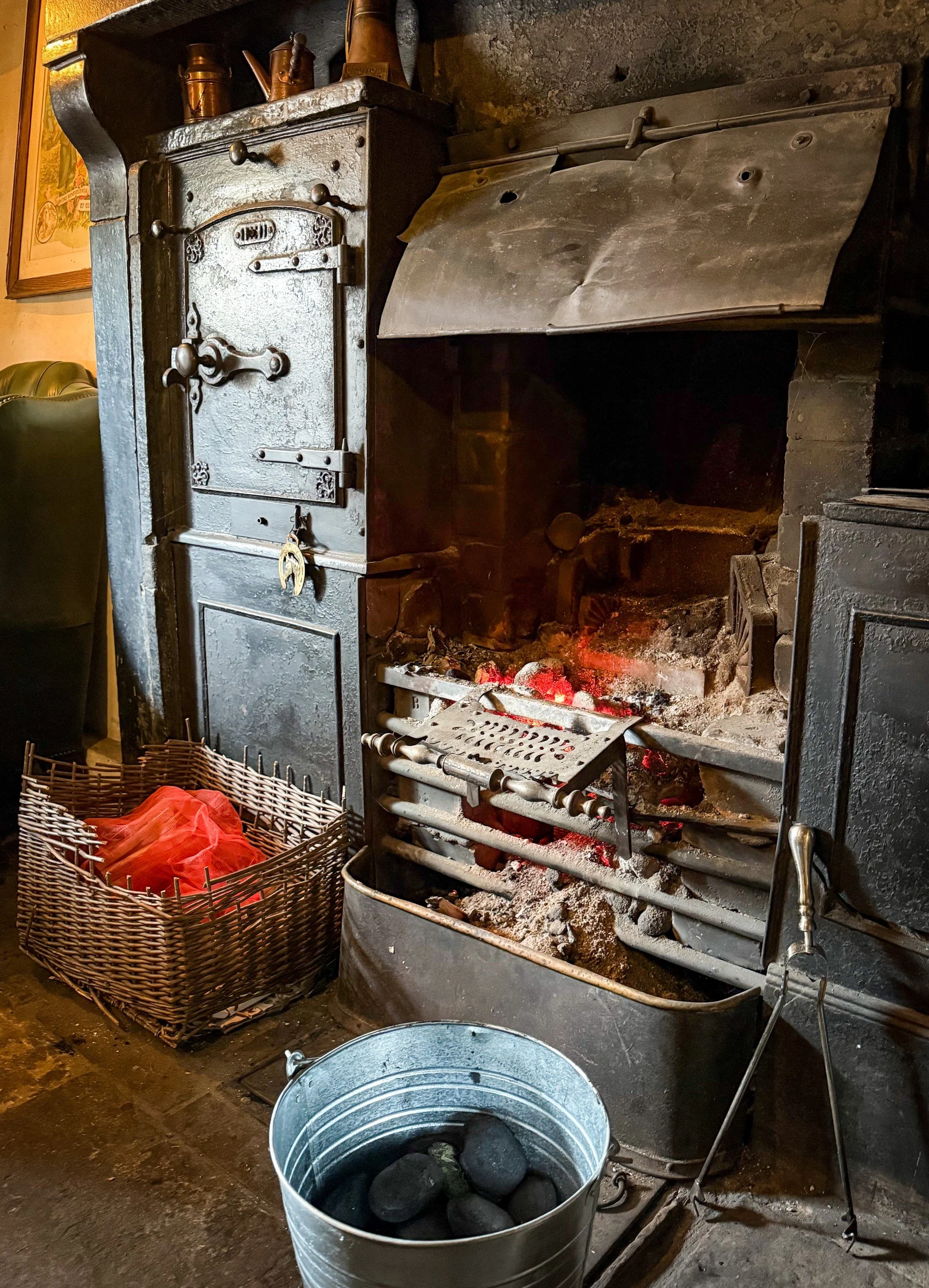 The cosy fireplace in a pub with period features and a range