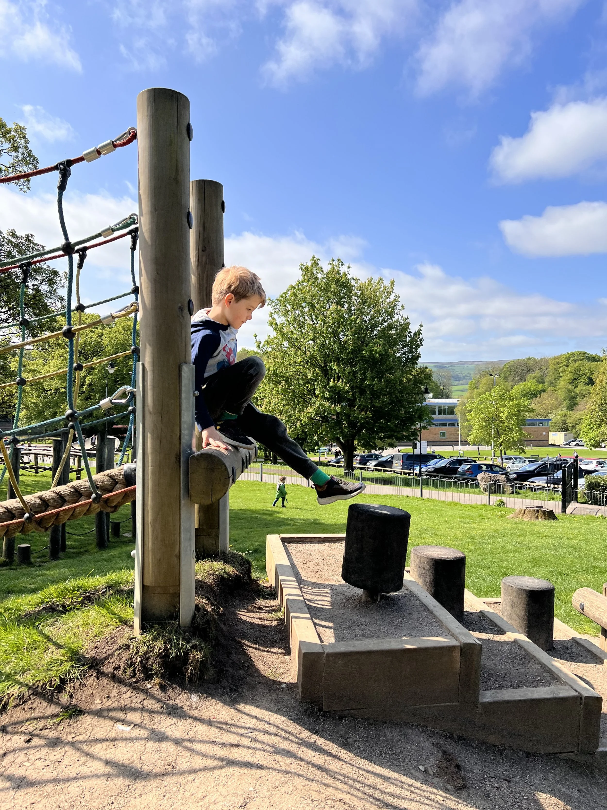 Child stretching out off of a rope bridge