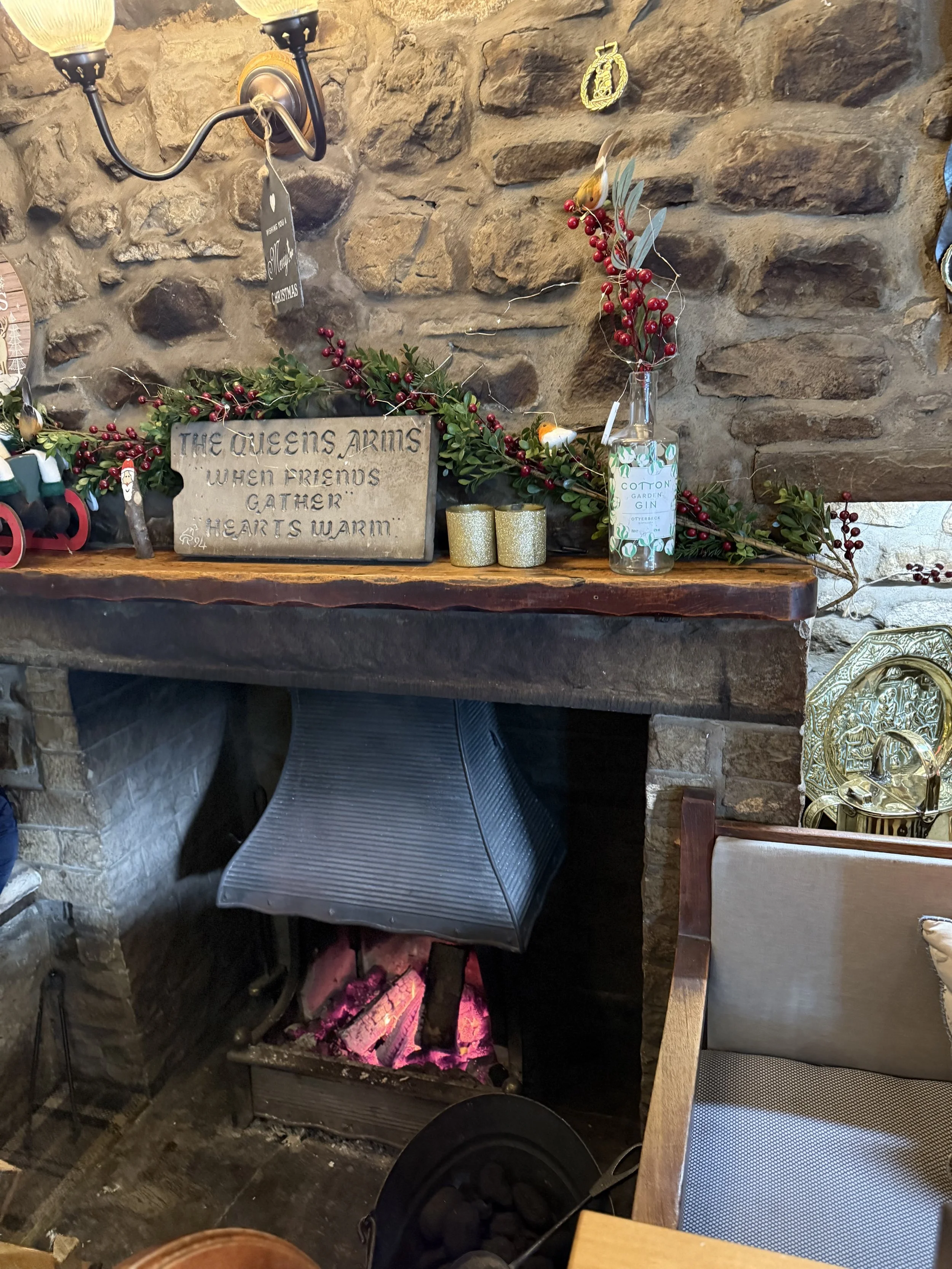 The fireplace in a pub with a sign referring to friends and warming up