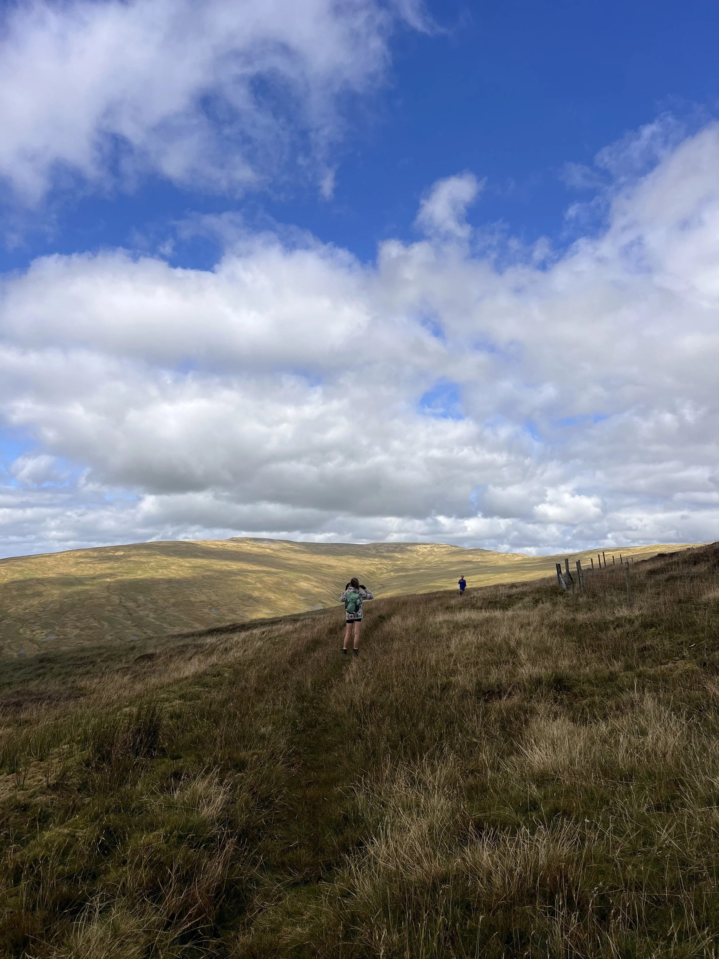 Child walking down a mountain with views to other mountains beyond