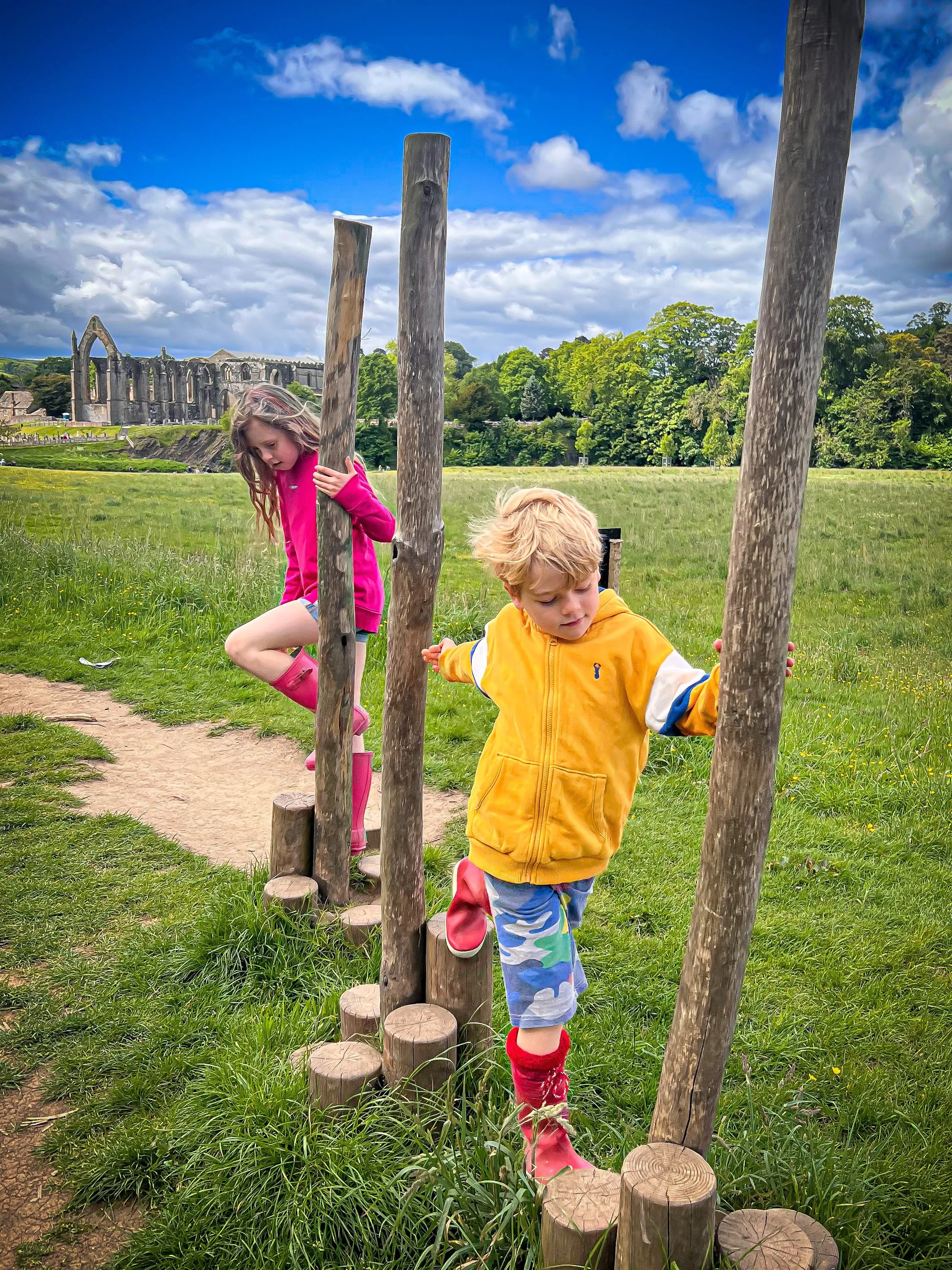 Children walking along an obstacle course with Bolton Abbey in the background