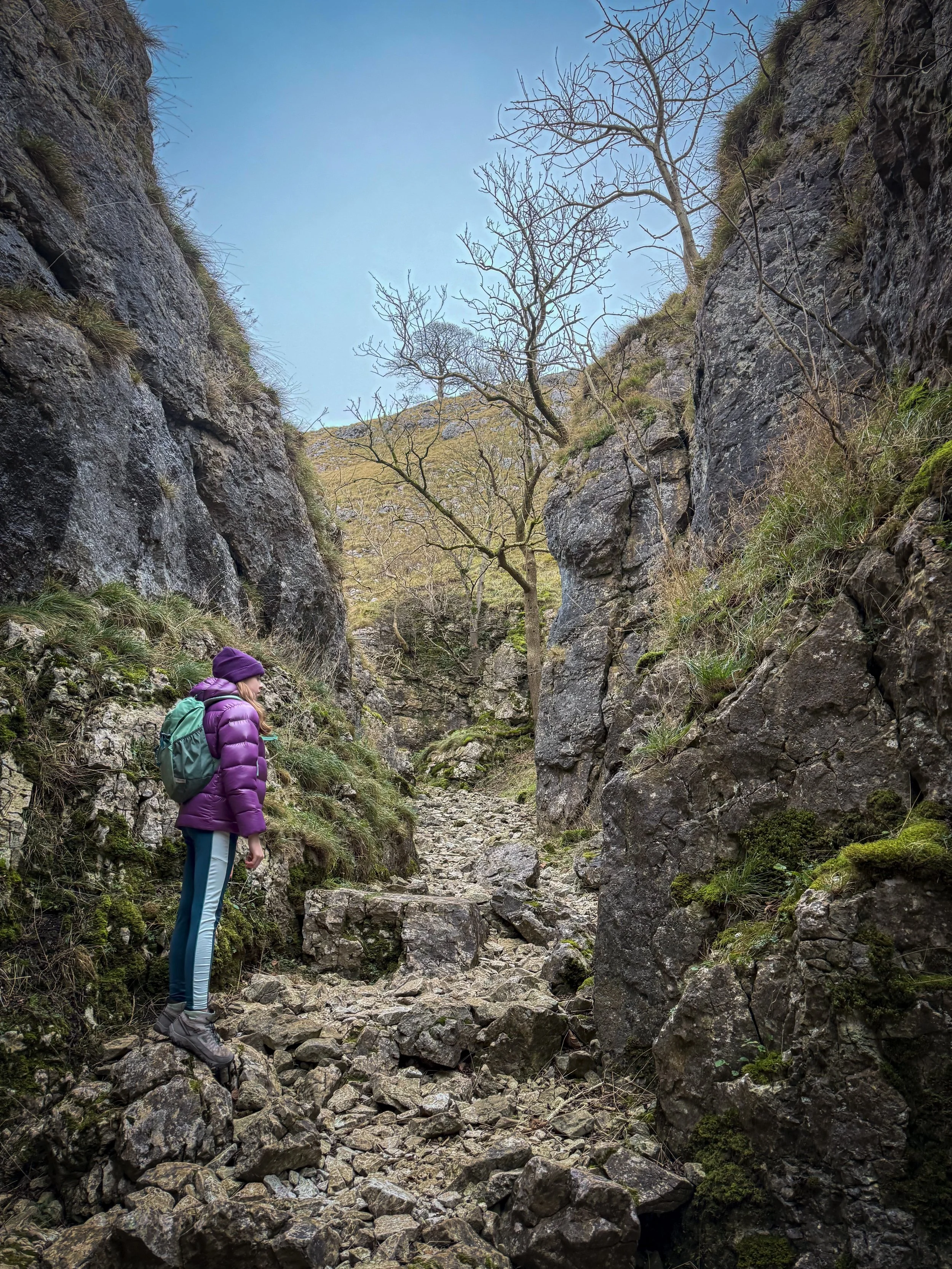 Child standing in a rocky gorge in winter