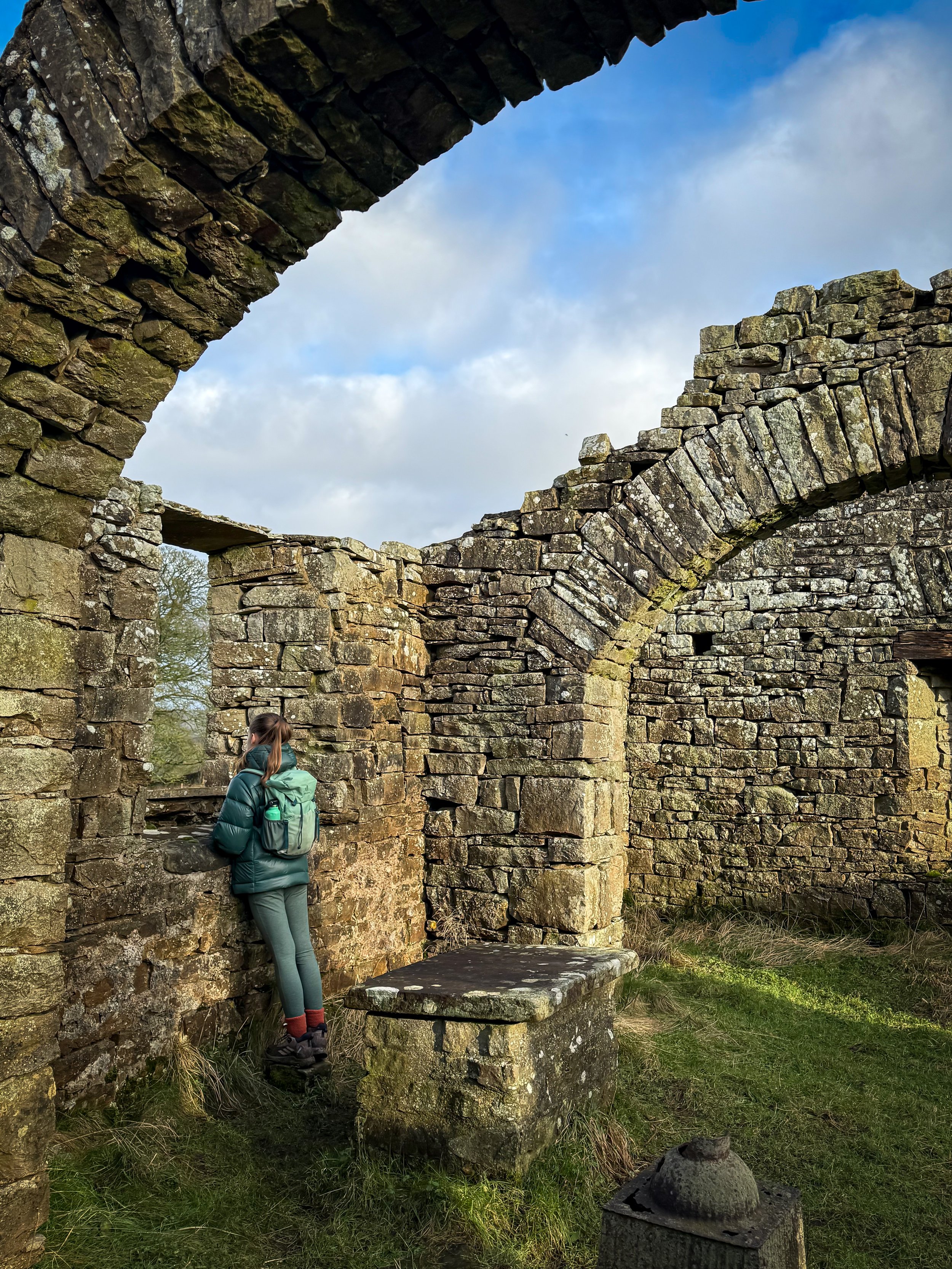 Looking out of the ruined window of a church with an altar behind