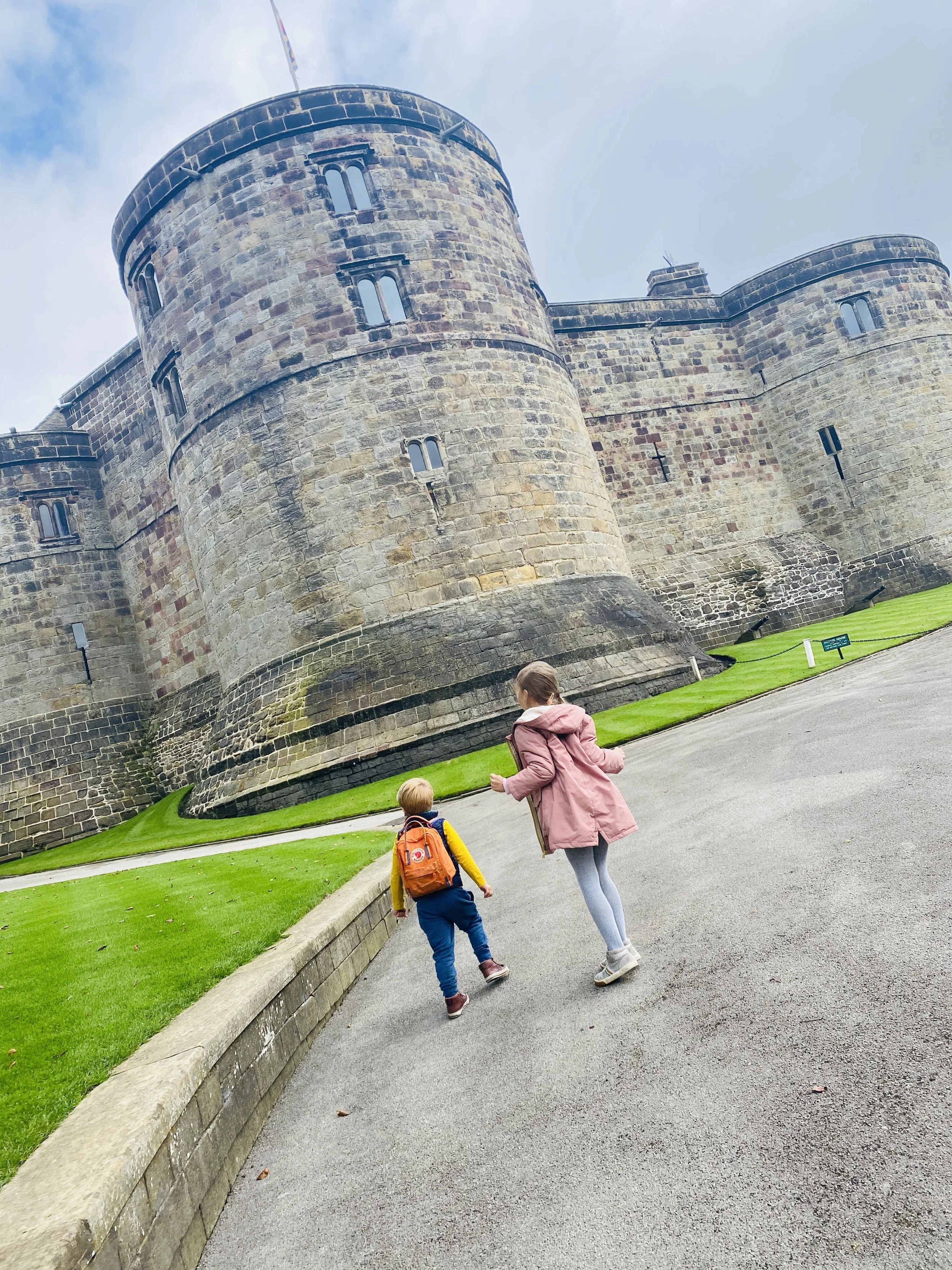 Two children walking in front of Skipton Castle