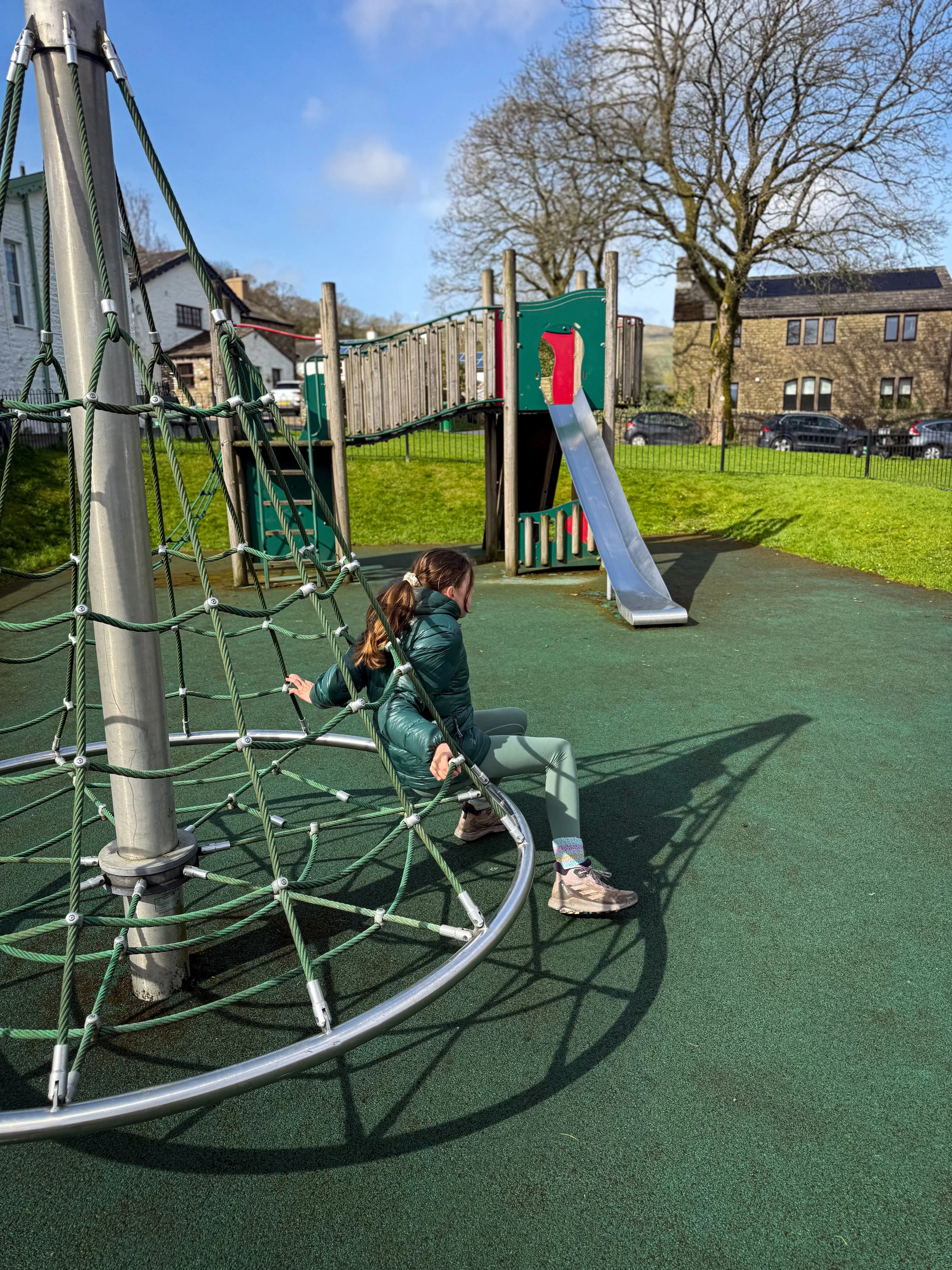 sitting on a roundabout at a playpark
