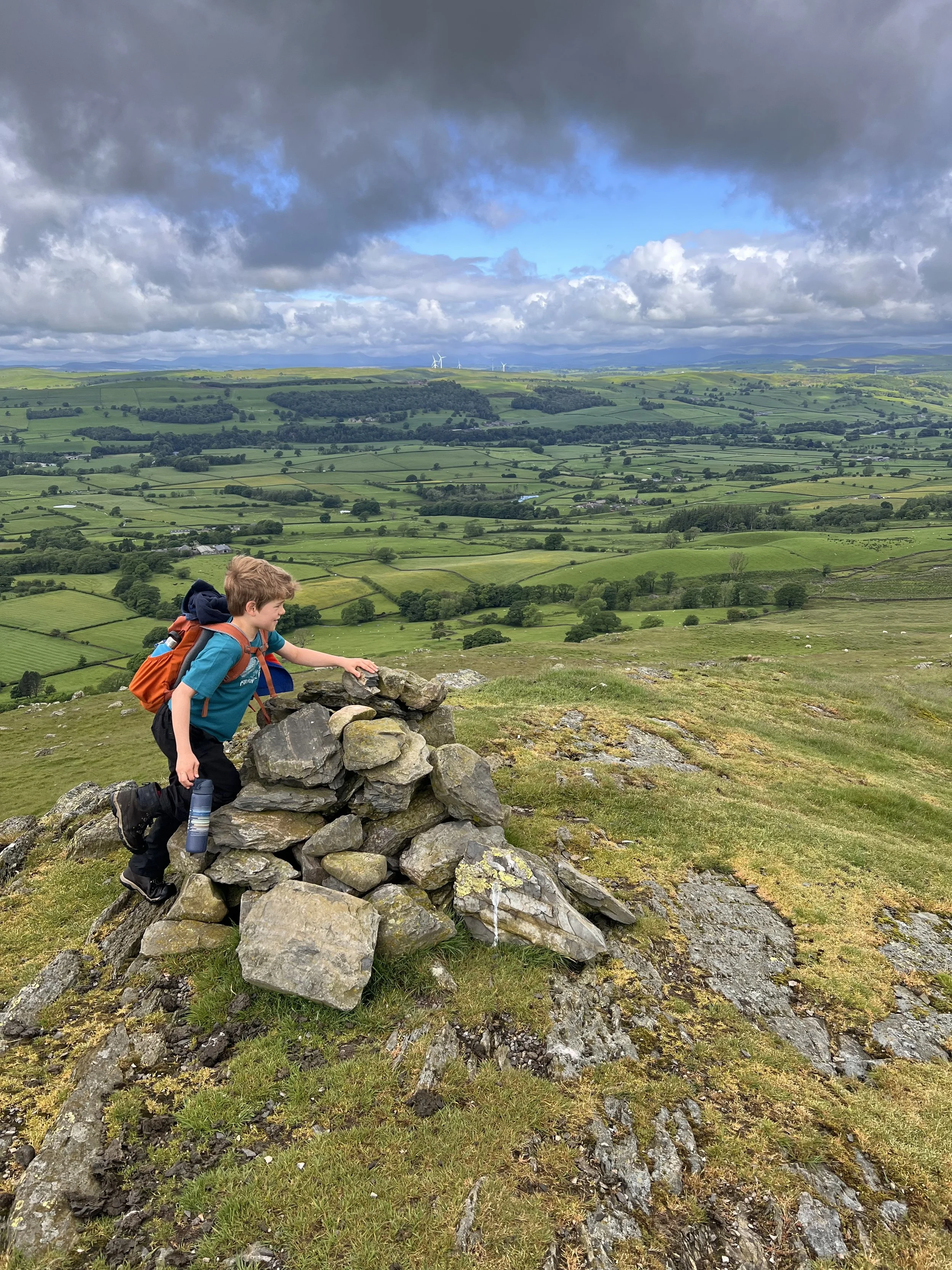 Child sat on cairn looking out at views