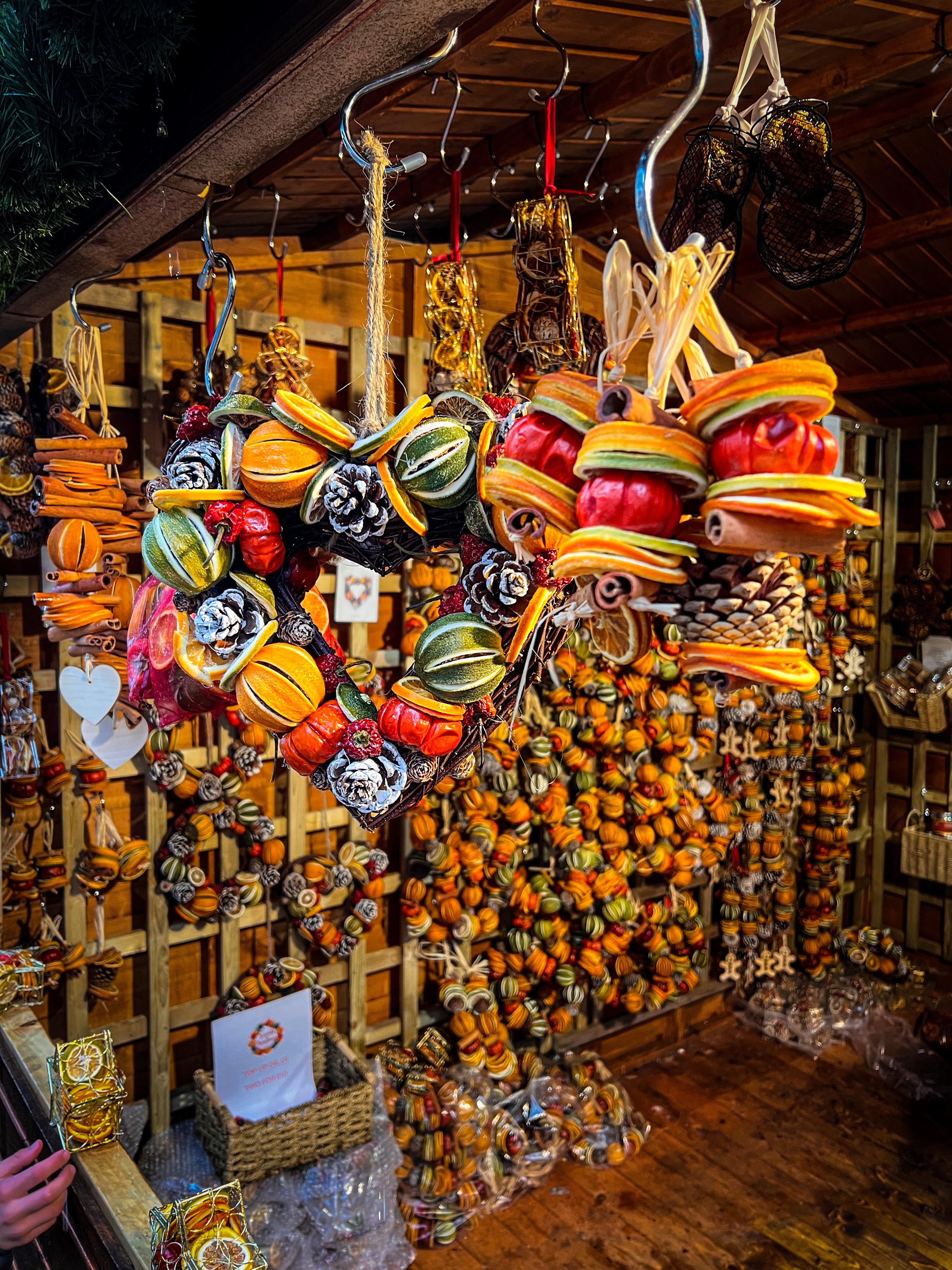 wreaths of dried fruit pine cones dried orange and festive spices hung on display in a chalet with christmas foliage