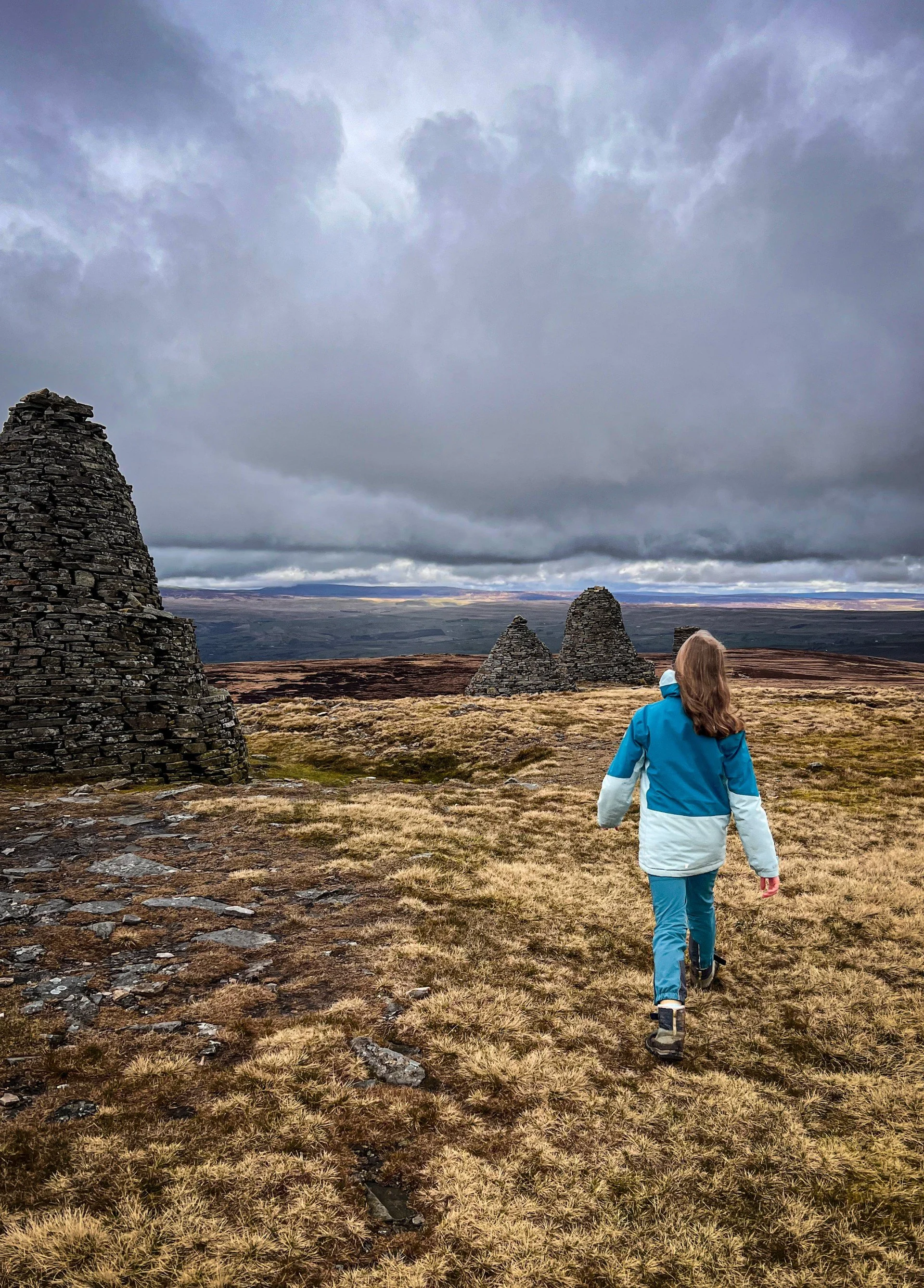 Child walking towards large cairns