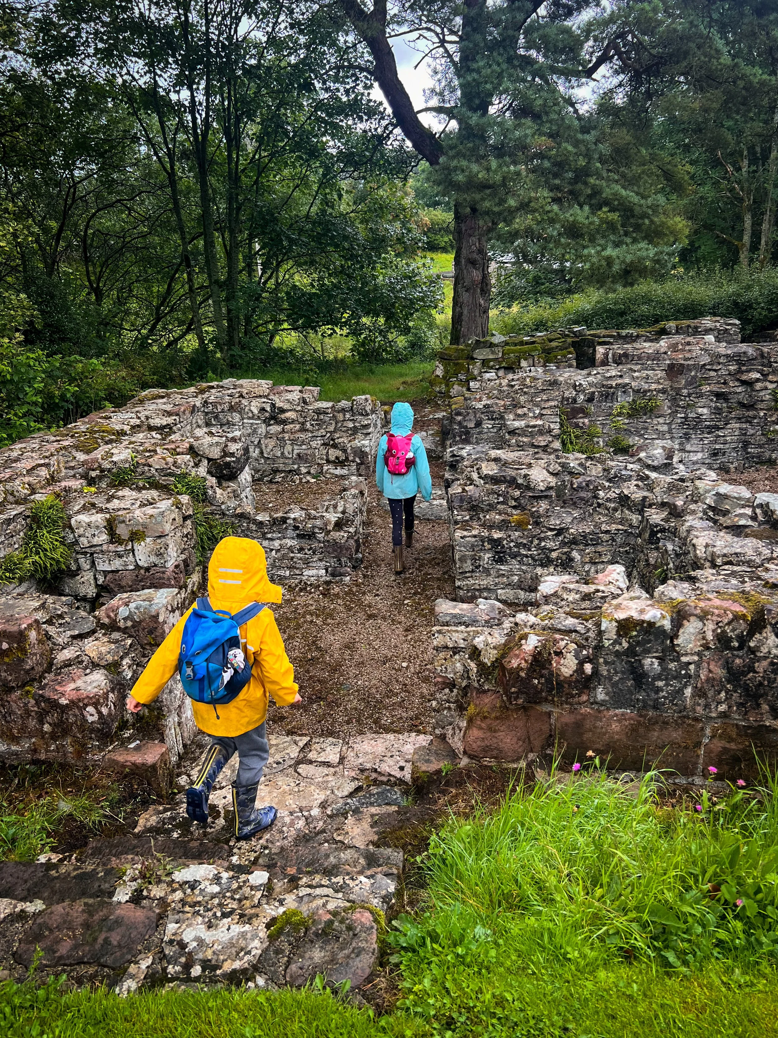 Children exploring a ruin in rain