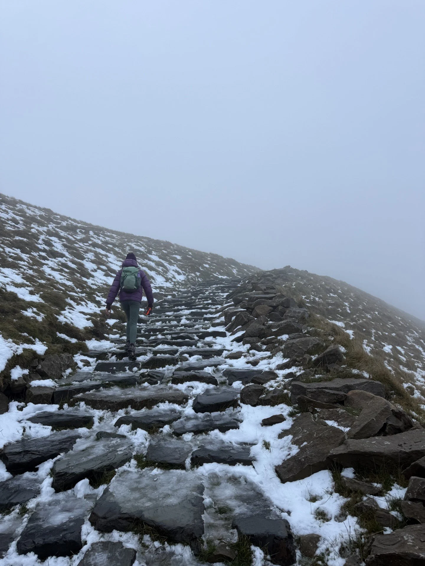 Child walking up stone steps in grey cloud and fog on a mountain