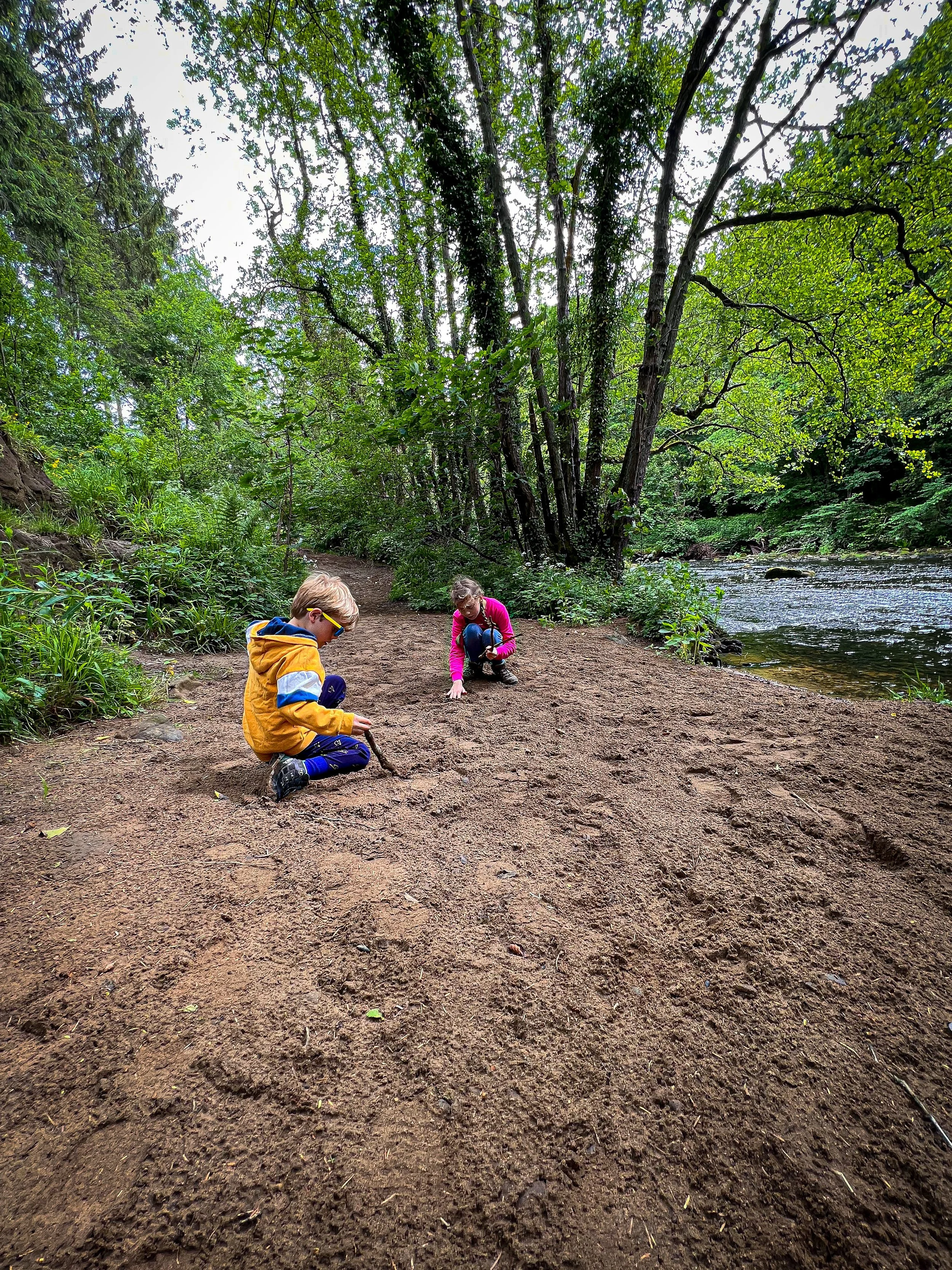 Children playing by the side of the River Nidd on a sandy beach