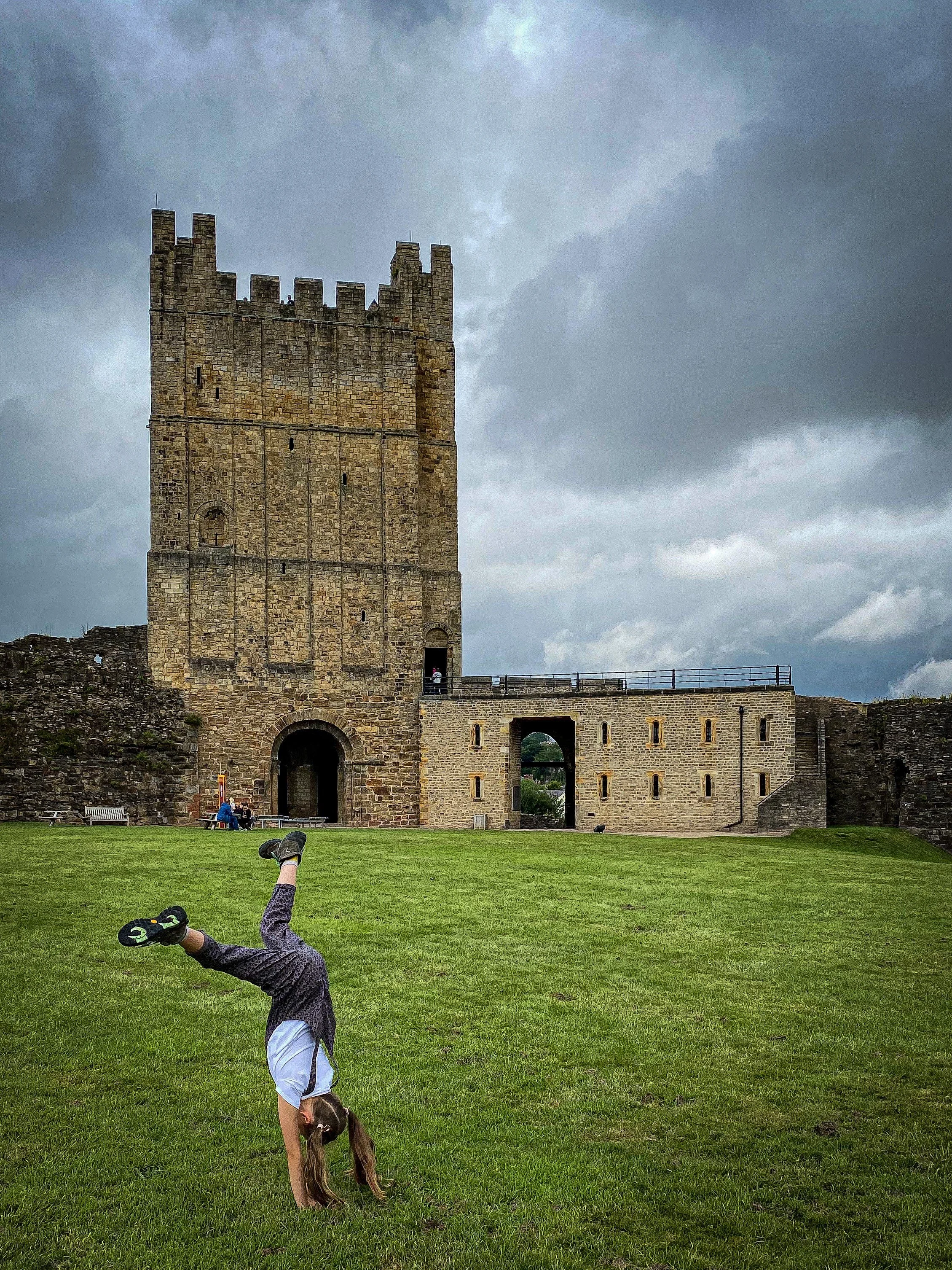 Child doing a cartwheel in front of a castle