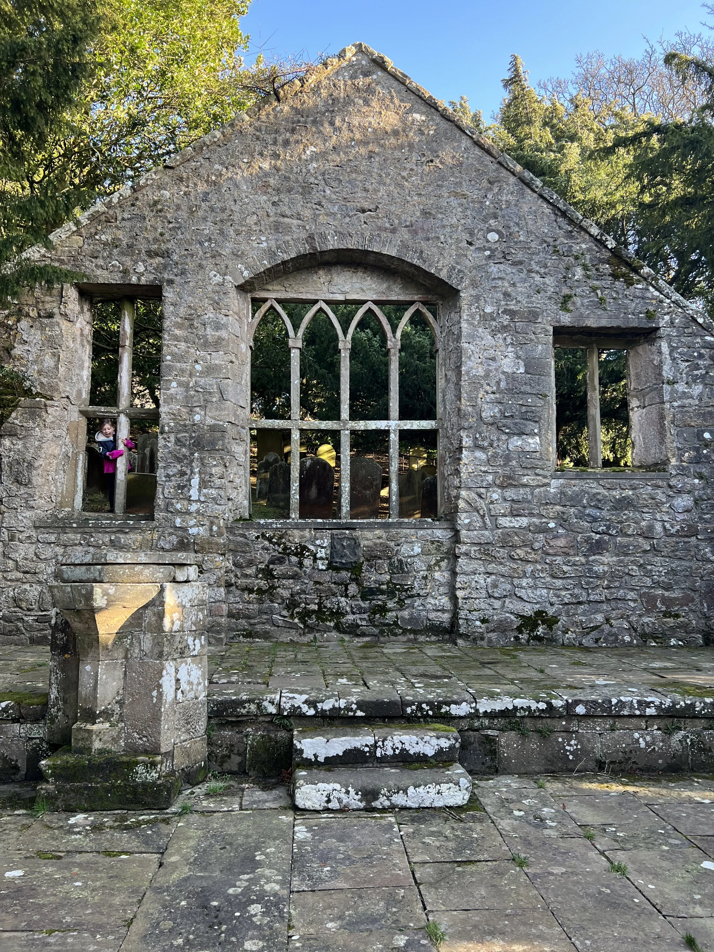 Child peering through church ruins and window