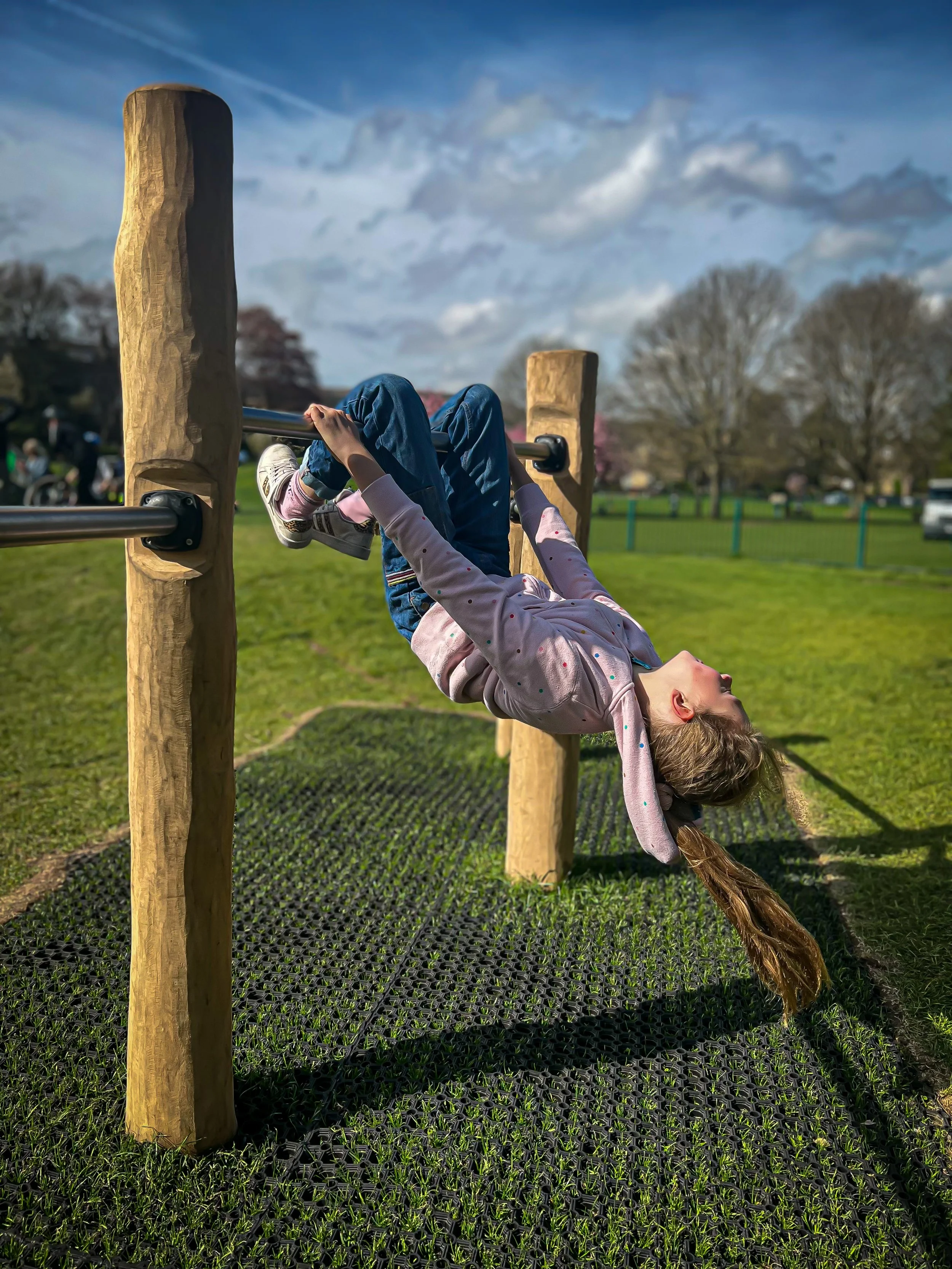 Swinging on the bar at Ilkley Play Park