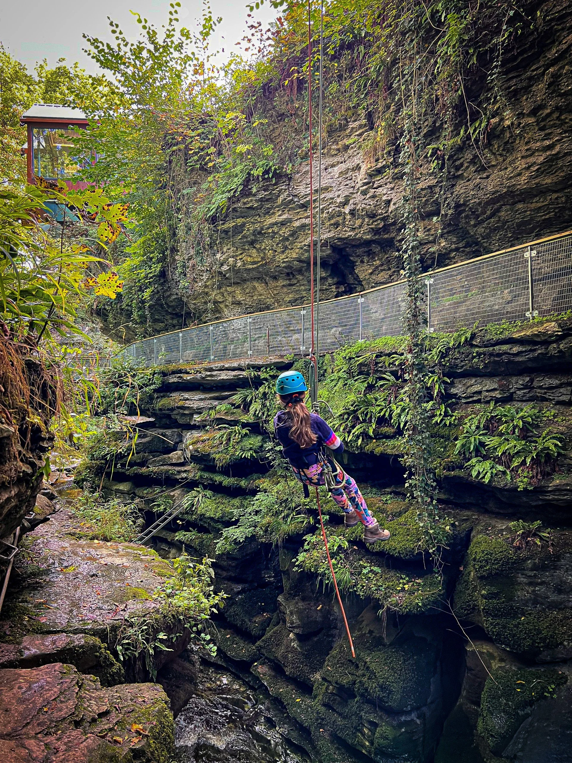 Child abseiling using ropes in a gorge