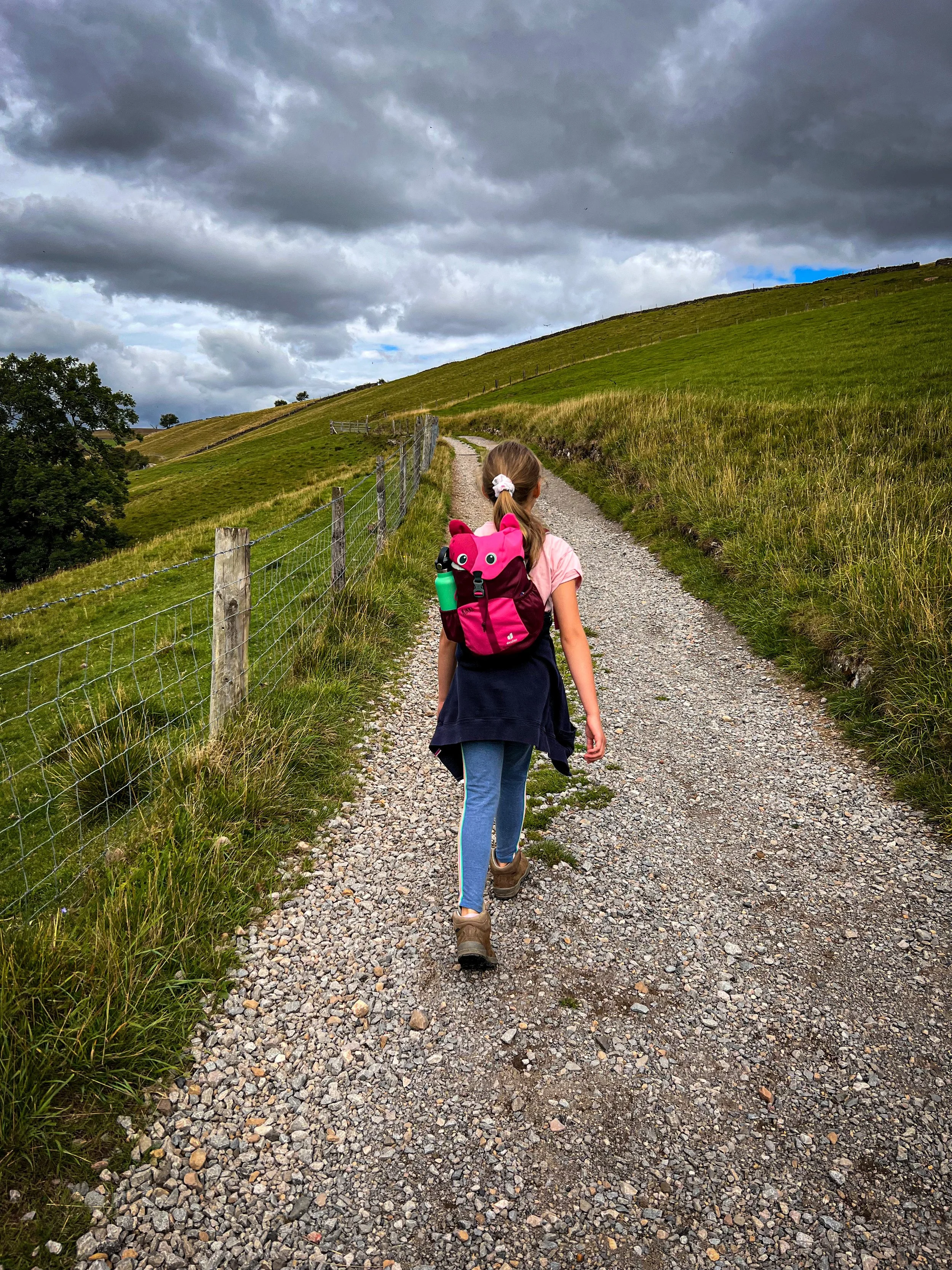 Child walking on a wide gravel track in the Yorkshire Dales