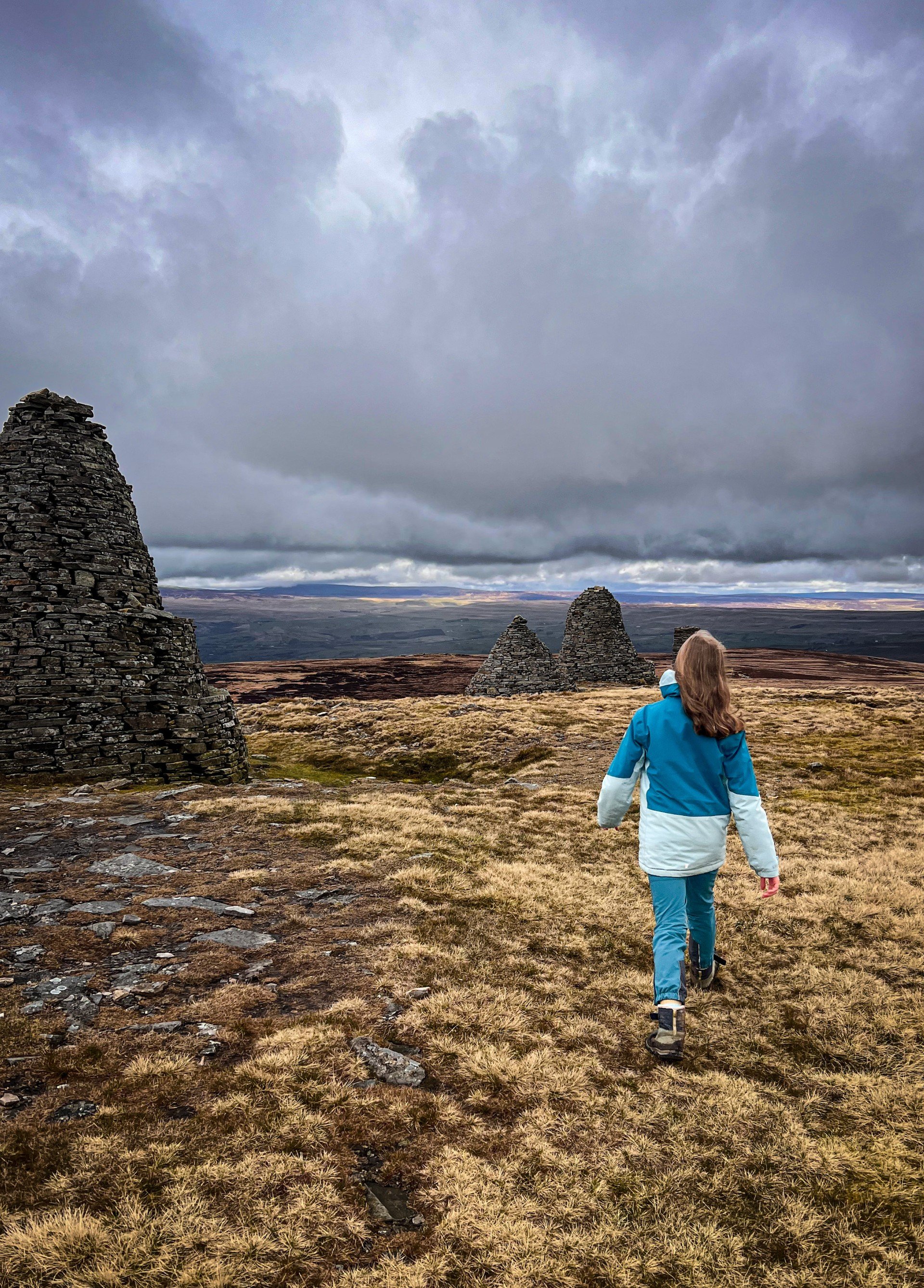 Child walking along a line of giant cairns