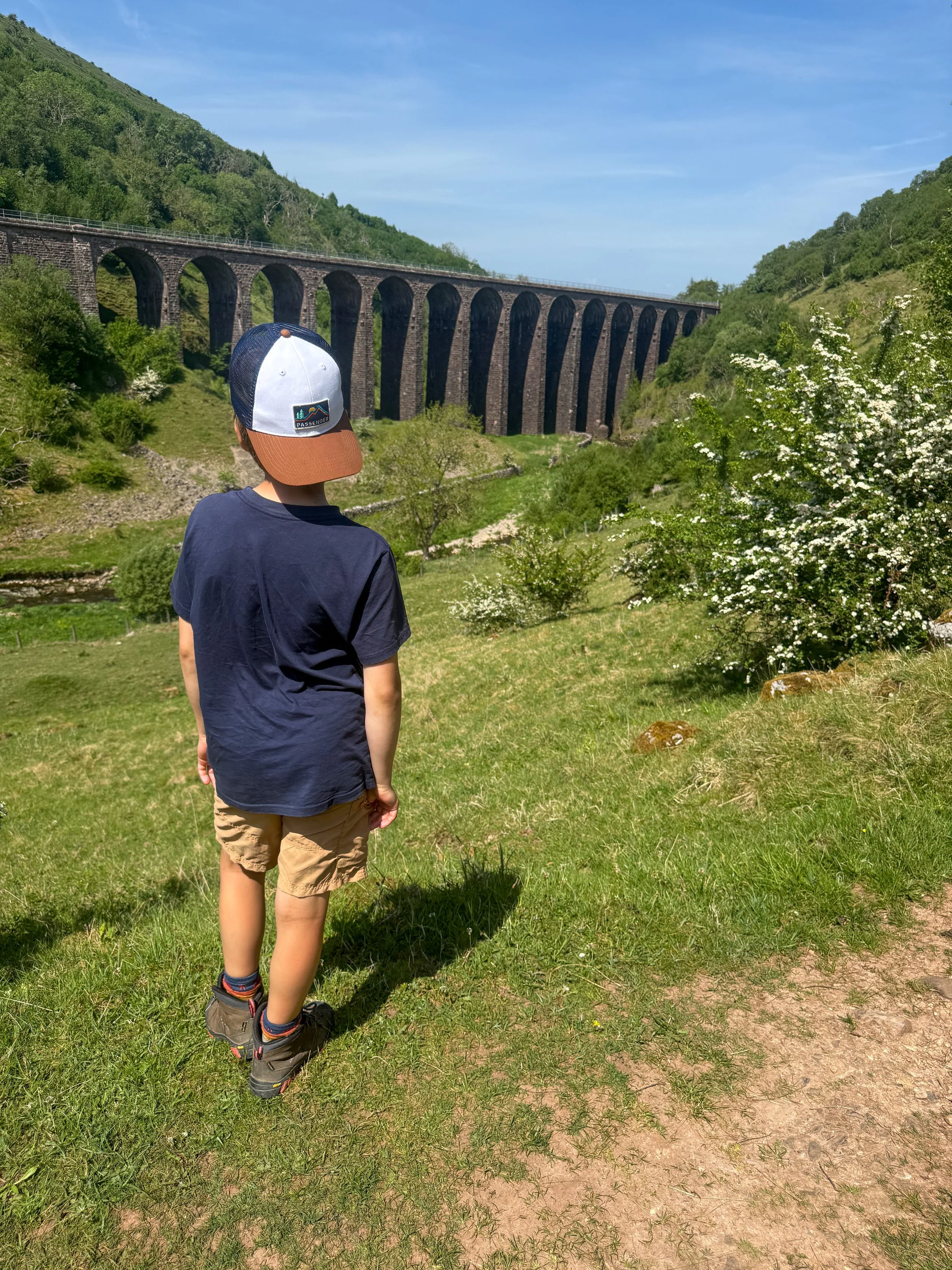 child standing in front of a viaduct