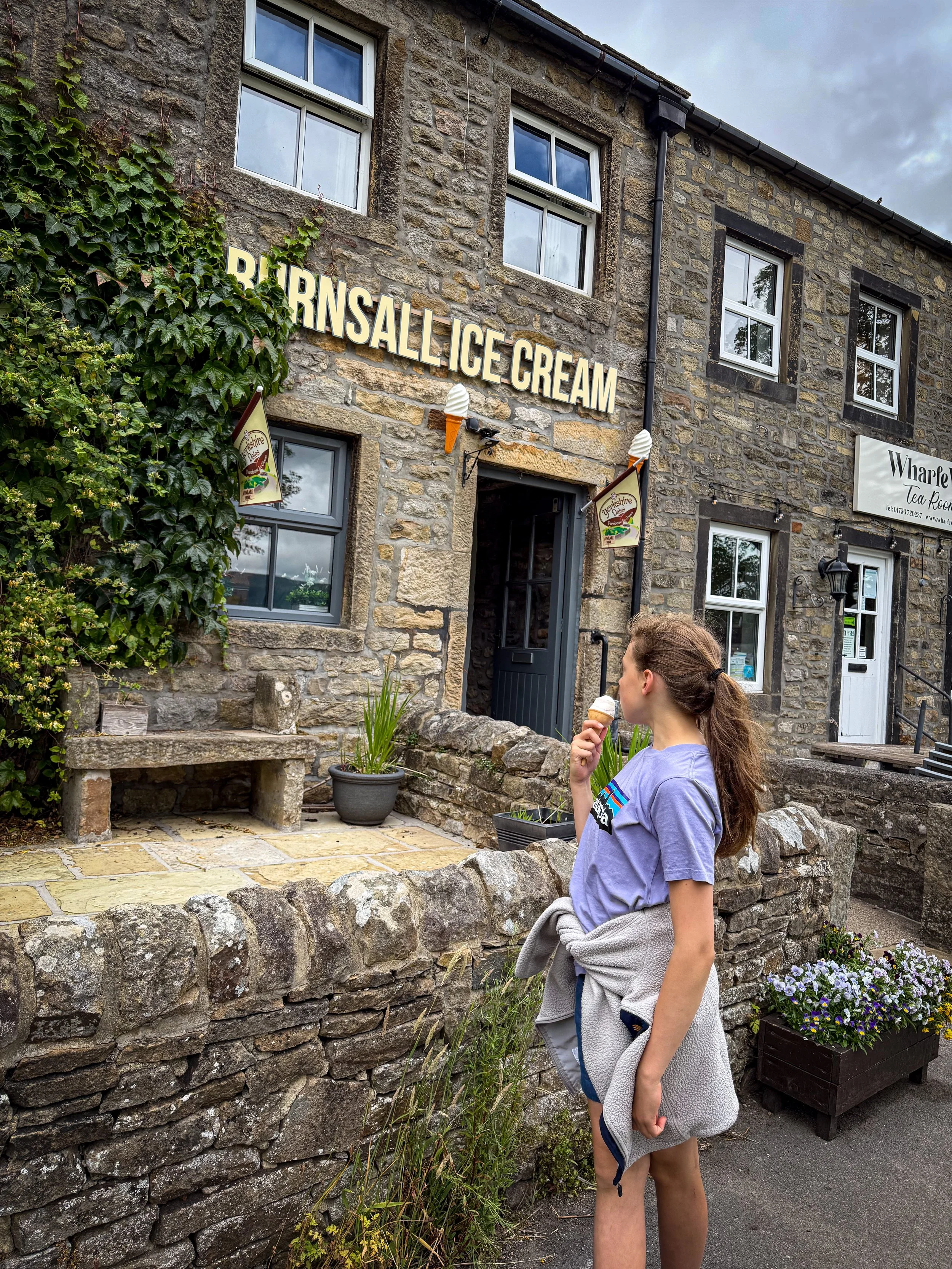 Child next to Burnsall Ice Cream parlour eating an ice cream