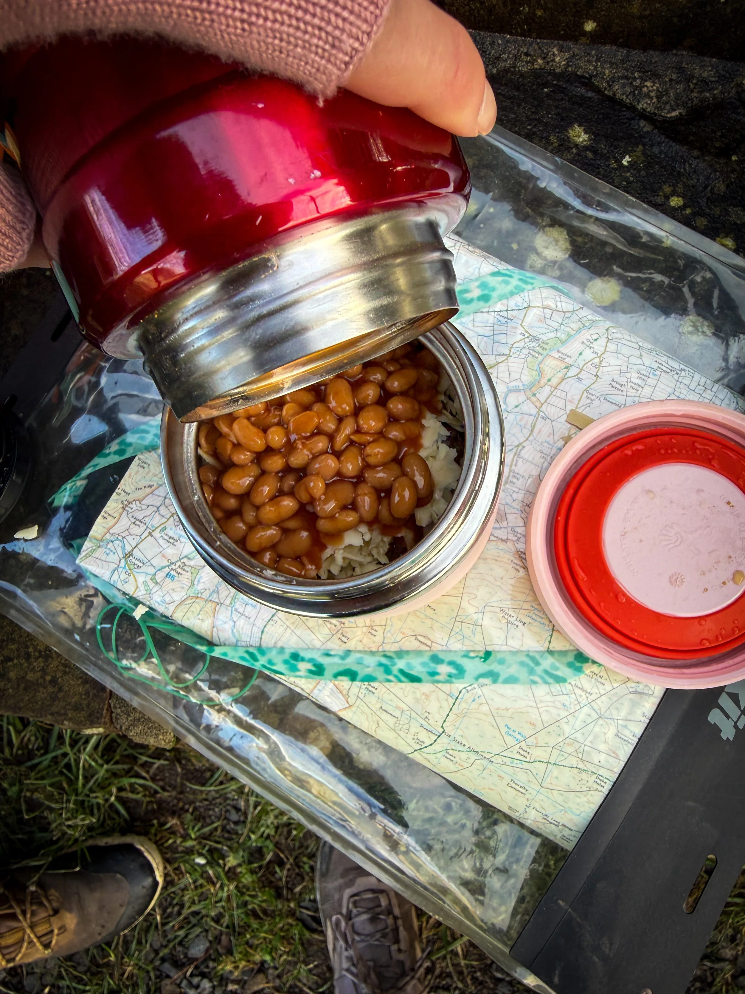 Pouring beans from a flask into a pot and on a baked potato