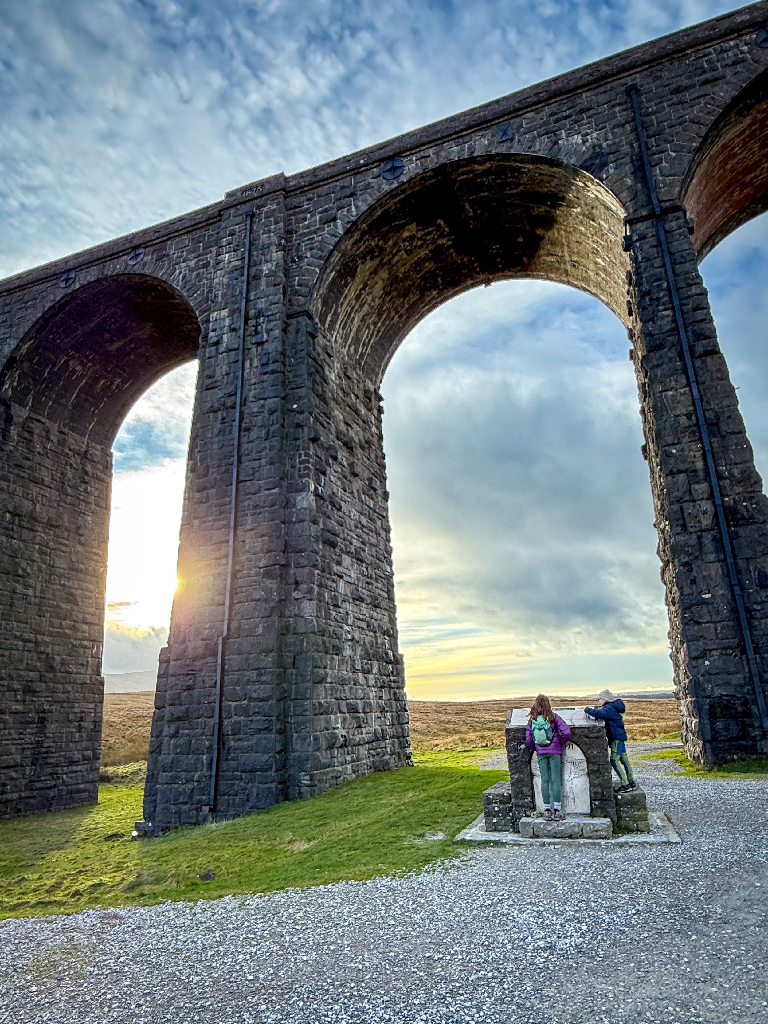 Children standing at the monument under the Ribblehead viaduct